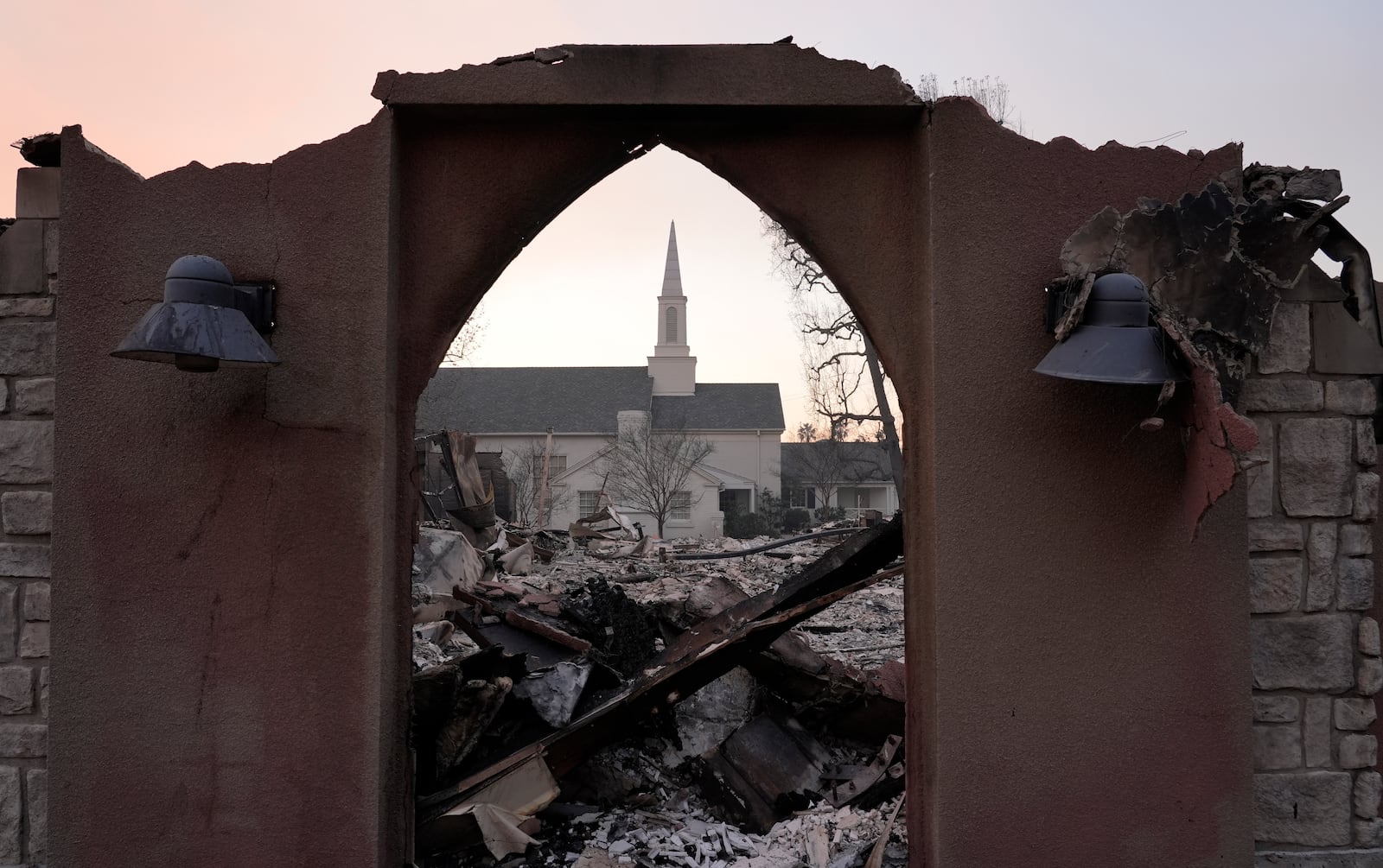 The intact First Church of Christ, Scientist is framed through the ruins of St. Mark's Episcopal Church next door, Thursday, Jan. 9, 2025, in Altadena, Calif. (AP Photo/Chris Pizzello)