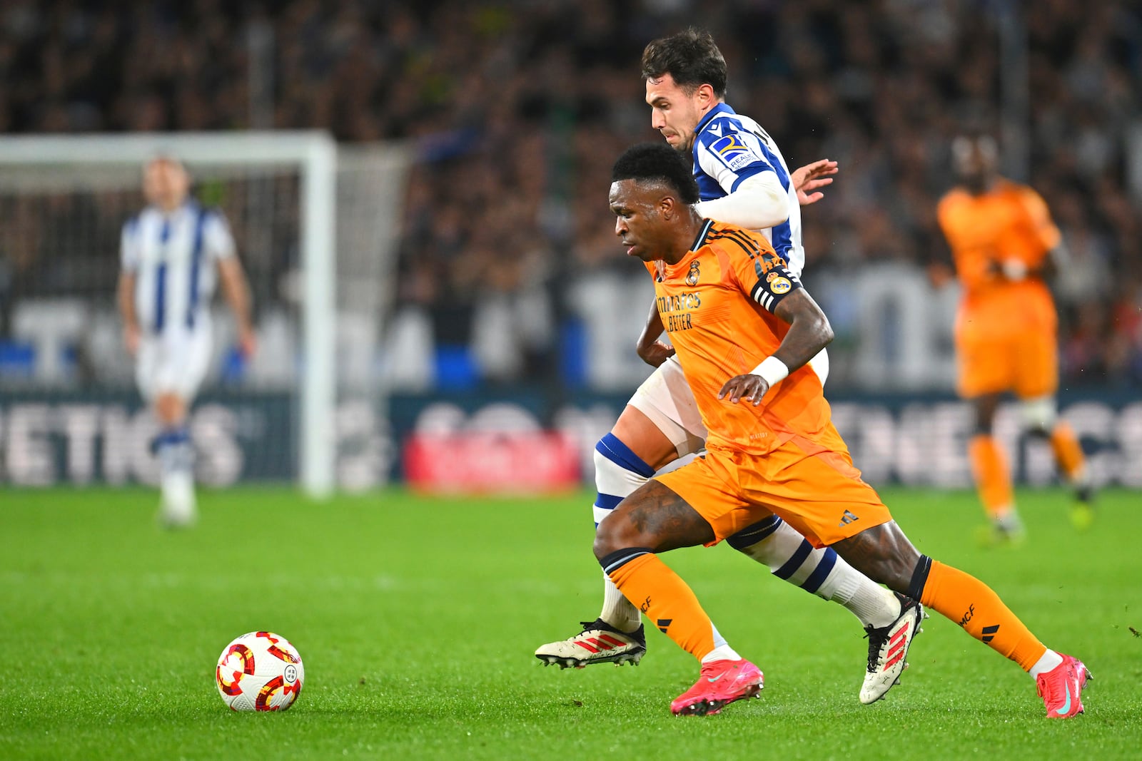 Real Sociedad's Martin Zubimendi, centre, challenges for the ball with Real Madrid's Vinicius Junior during the Spanish Copa del Rey soccer match between Real Sociedad and Real Madrid at the Reale Arena in San Sebastian, Spain, Wednesday, Feb. 26, 2025. (AP Photo/Miguel Oses)