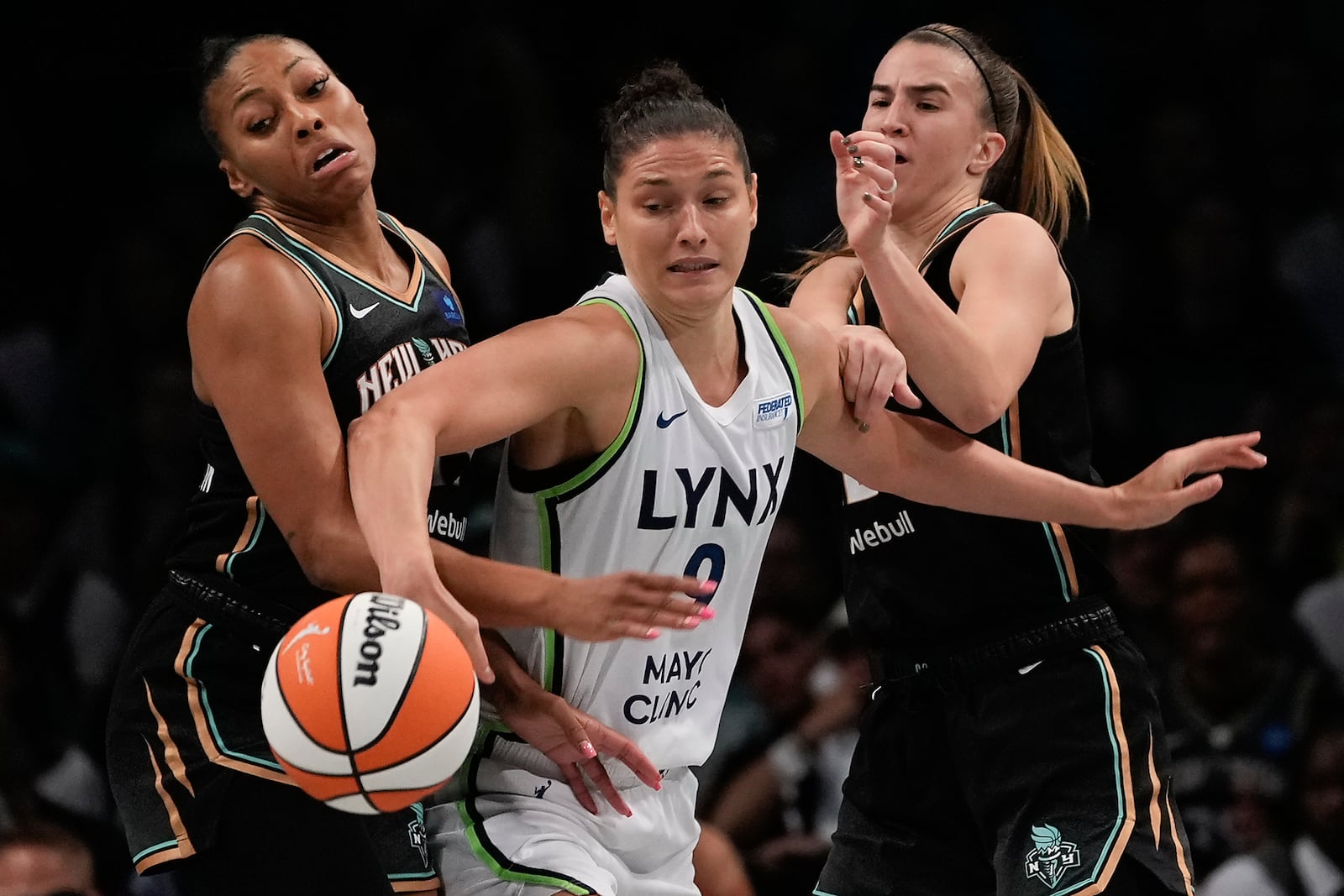 Minnesota Lynx forward Cecilia Zandalasini (9) battles for a loose ball against New York Liberty forward Betnijah Laney-Hamilton, left, and guard Sabrina Ionescu, right, during the second quarter of Game 5 of the WNBA basketball final series, Sunday, Oct. 20, 2024, in New York. (AP Photo/Pamela Smith)