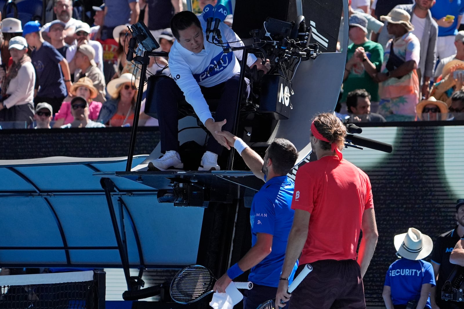 Novak Djokovic of Serbia shakes hands with chair umpire James Keothavong after retiring from his semifinal against Alexander Zverev of Germany at the Australian Open tennis championship in Melbourne, Australia, Friday, Jan. 24, 2025. (AP Photo/Asanka Brendon Ratnayake)