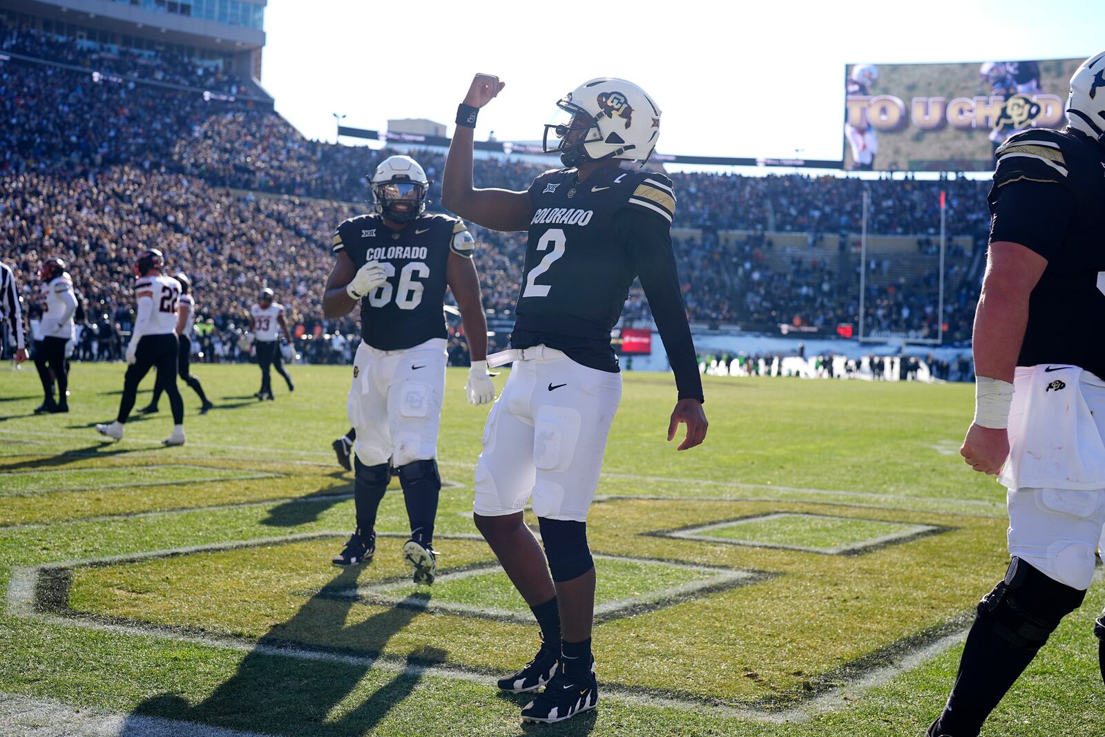 Colorado quarterback Shedeur Sanders, front, gestures after throwing a touchdown pass to wide receiver LaJohntay Wester as offensive lineman Justin Mayers looks on in the first half of an NCAA college football game against Oklahoma State Friday, Nov. 29, 2024, in Boulder, Colo. (AP Photo/David Zalubowski)