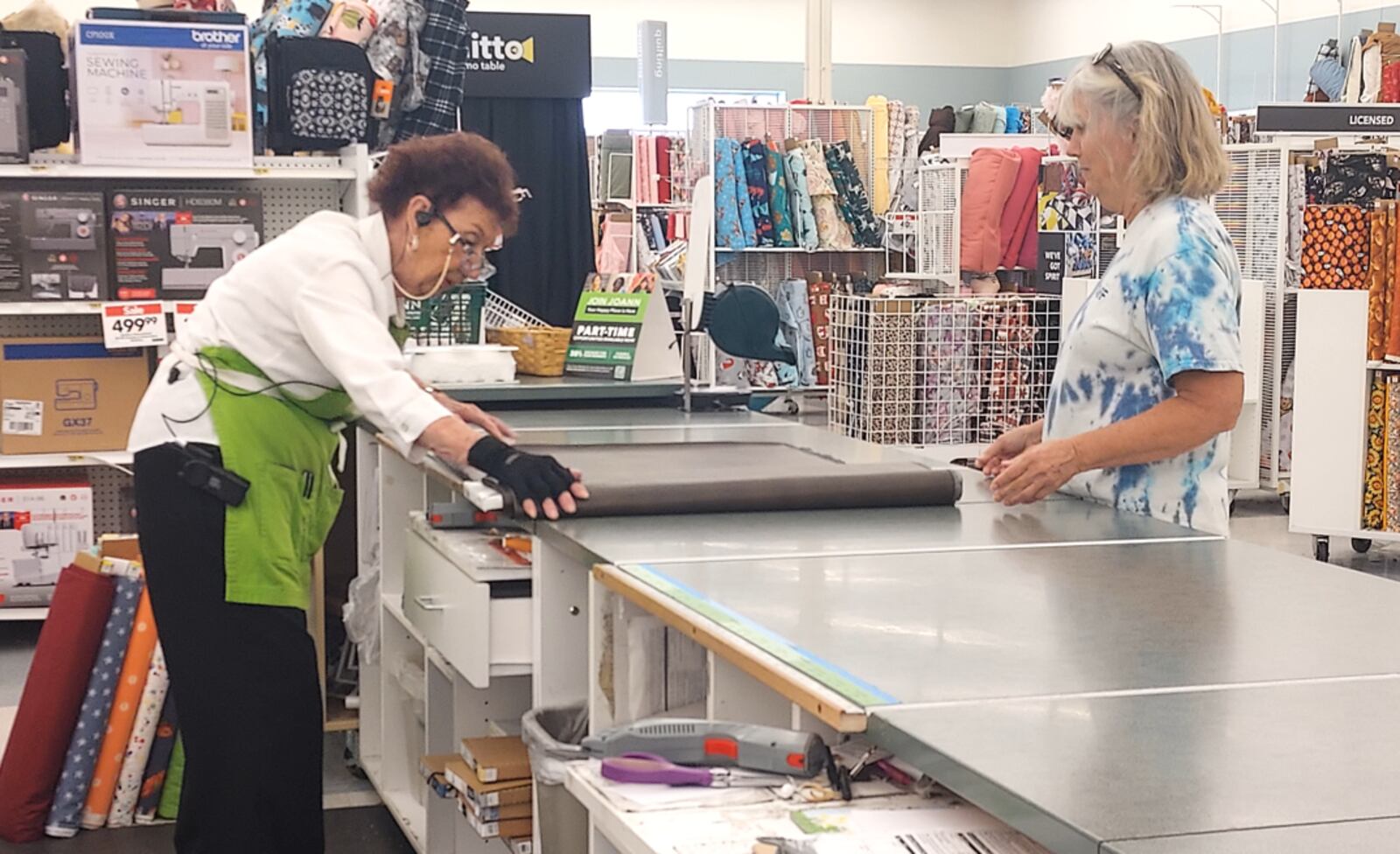 During her shift at Jo-Ann in Mason, 101-year-old Jayne Burns cuts fabric. She makes remnants of pieces of fabric that
are less than a yard. She also puts away the fabric and organizes thread when she’s not working with customers. CONTRIBUTED