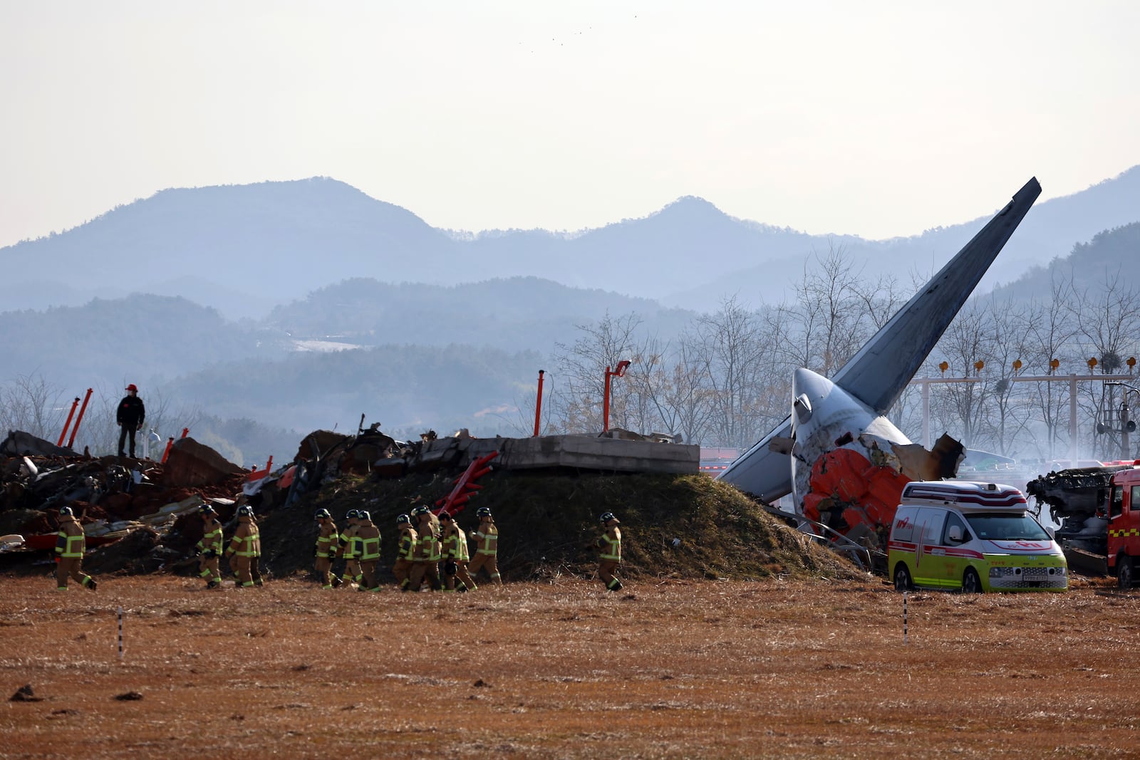 Firefighters and rescue team members work at Muan International Airport in Muan, South Korea, Sunday, Dec. 29, 2024. (Cho Nam-soo/Yonhap via AP)