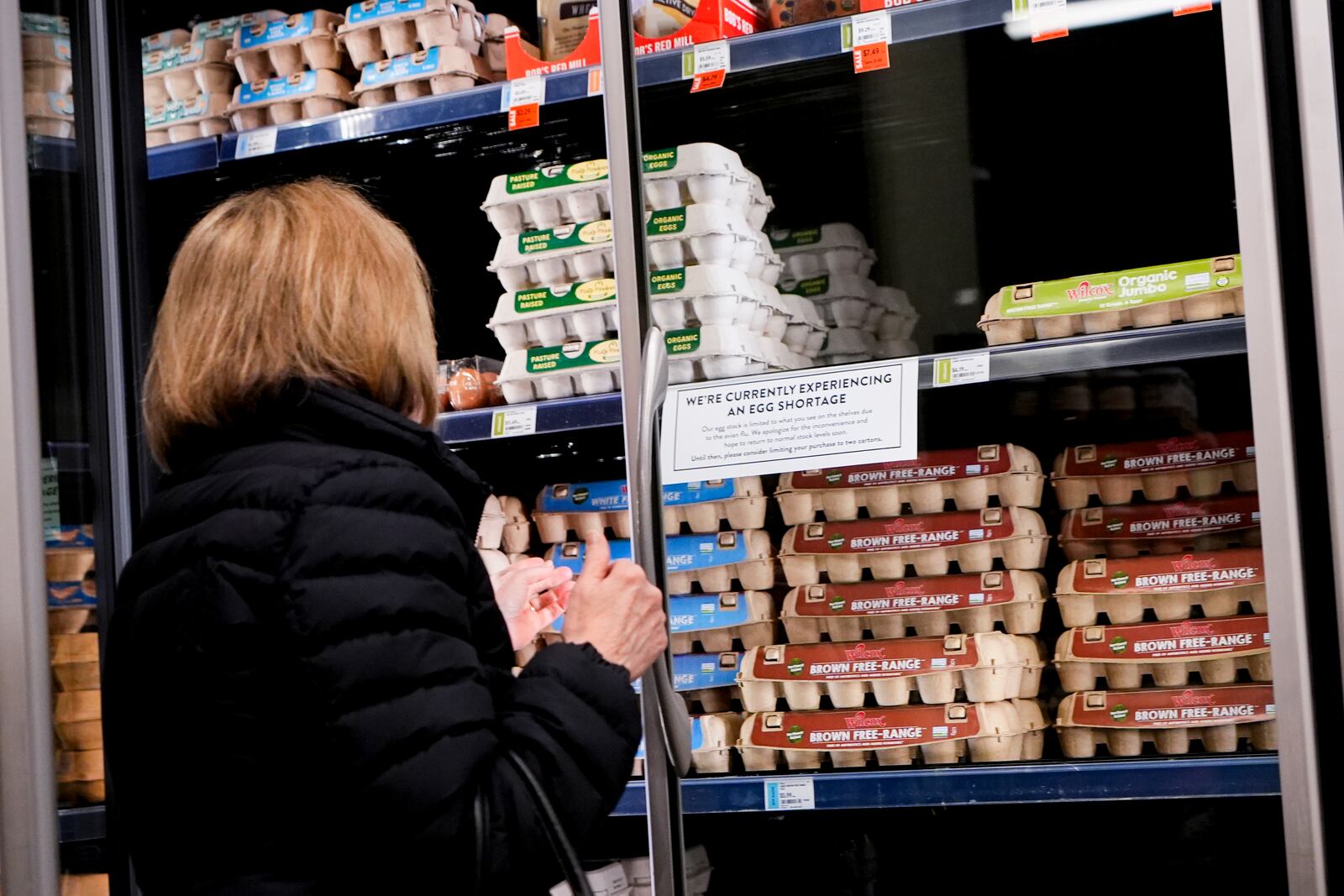 A shopper browses for eggs in front of a sign posted about egg shortages at a PCC Community Markets grocery store Monday, Jan. 27, 2025, in Seattle. (AP Photo/Lindsey Wasson)