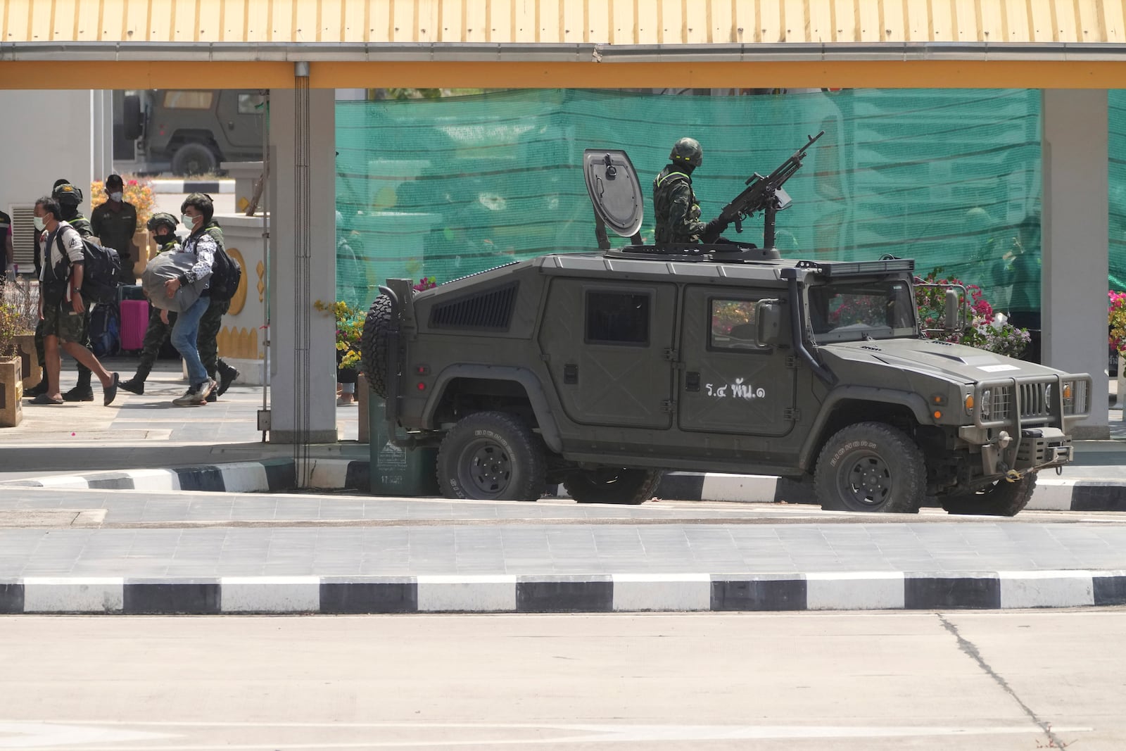 Thai soldiers provide security for the transfer of Indonesia nationals who had worked at scam centers in eastern Myanmar, on their arrival at Thailand's Mae Sot, Tak province before being sent back to Indonesia on Thursday, Feb. 27, 2025. (AP Photo/Sakchai Lalit)