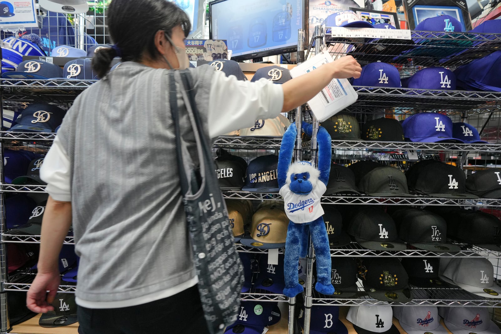 A customer shops around for goods related to Shohei Ohtani of the Los Angeles Dodgers at a sporting goods store, "SELECTION," in Shinjuku district Wednesday, Oct. 23, 2024 in Tokyo. (AP Photo/Eugene Hoshiko)