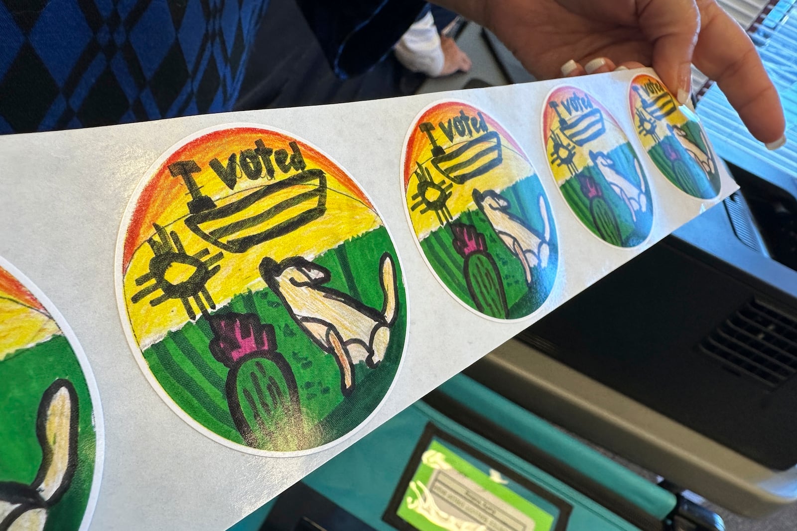 An election worker holds up a roll of I Voted stickers designed by a student in Albuquerque, N.M., on Wednesday, Oct. 30, 2024. (AP Photo/Susan Montoya Bryan)