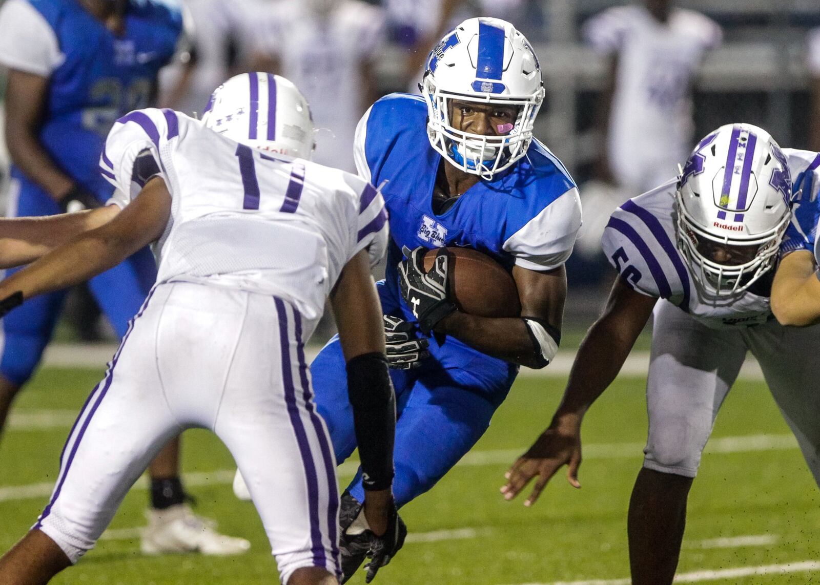 Hamilton’s Kaleb Johnson carries the ball between two Middletown defenders, including Kenny Wilson (17), during Friday night’s game at Virgil Schwarm Stadium in Hamilton. Host Big Blue won 15-14. NICK GRAHAM/STAFF