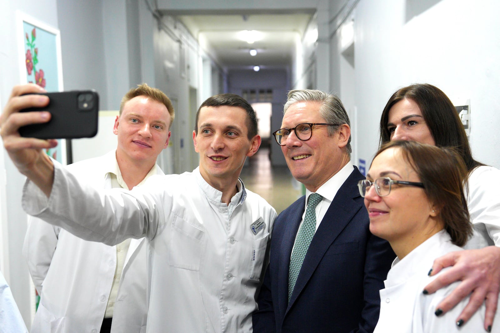 Britain's Prime Minister Keir Starmer poses for photos with staff members during a visit to a hospital, in Kyiv, Ukraine Thursday, Jan. 16, 2025. (Carl Court/Pool Photo via AP)