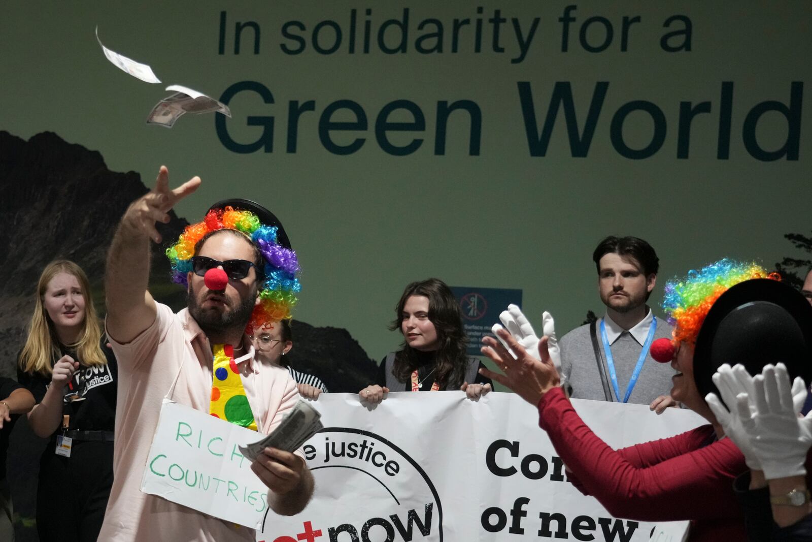 Activists dressed as clowns participate in a demonstration for climate finance at the COP29 U.N. Climate Summit, Friday, Nov. 22, 2024, in Baku, Azerbaijan. (AP Photo/Sergei Grits)