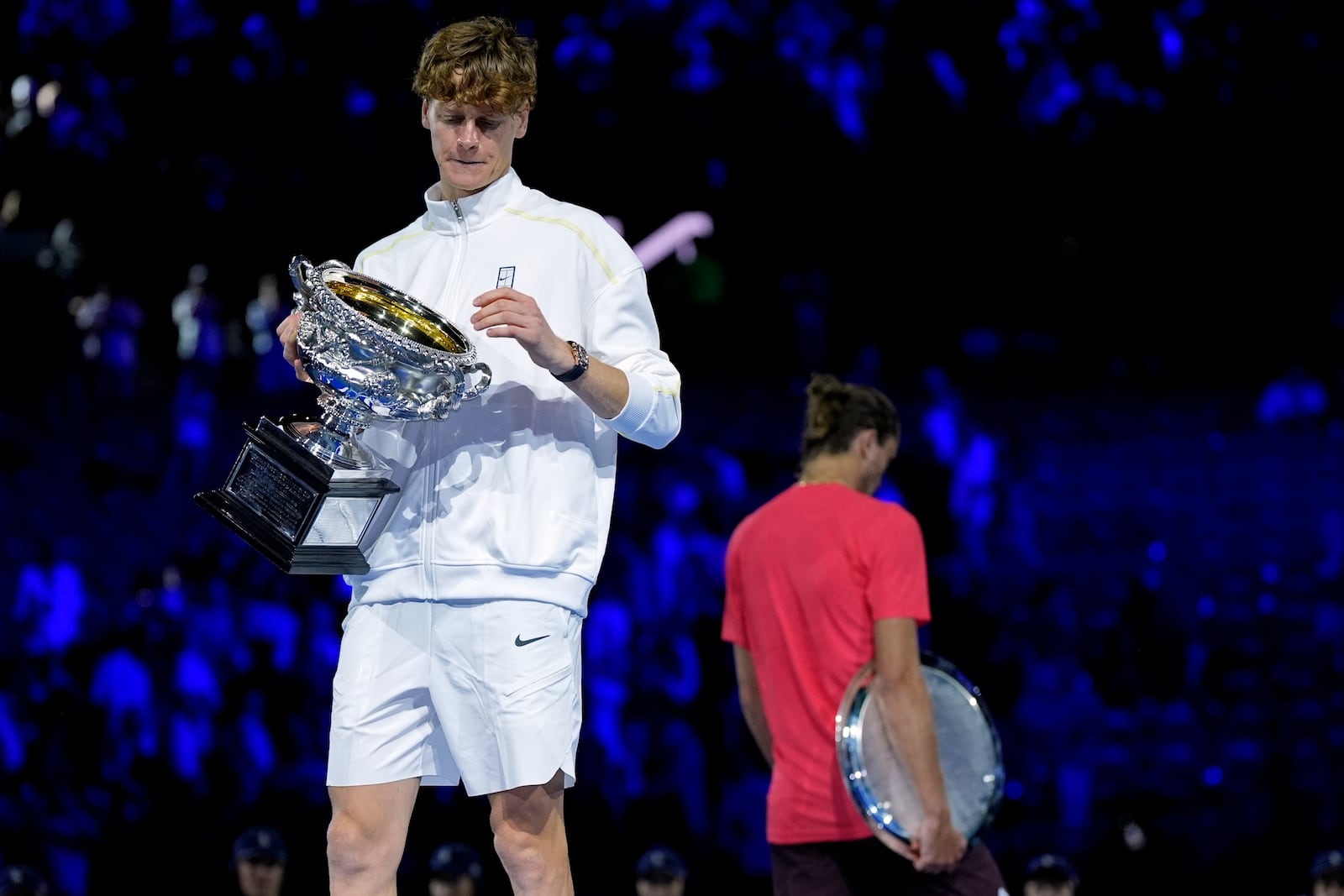 Jannik Sinner of Italy holds the Norman Brookes Challenge Cup after defeating Alexander Zverev, right, of Germany in the men's singles final at the Australian Open tennis championship in Melbourne, Australia, Sunday, Jan. 26, 2025. (AP Photo/Asanka Brendon Ratnayake)