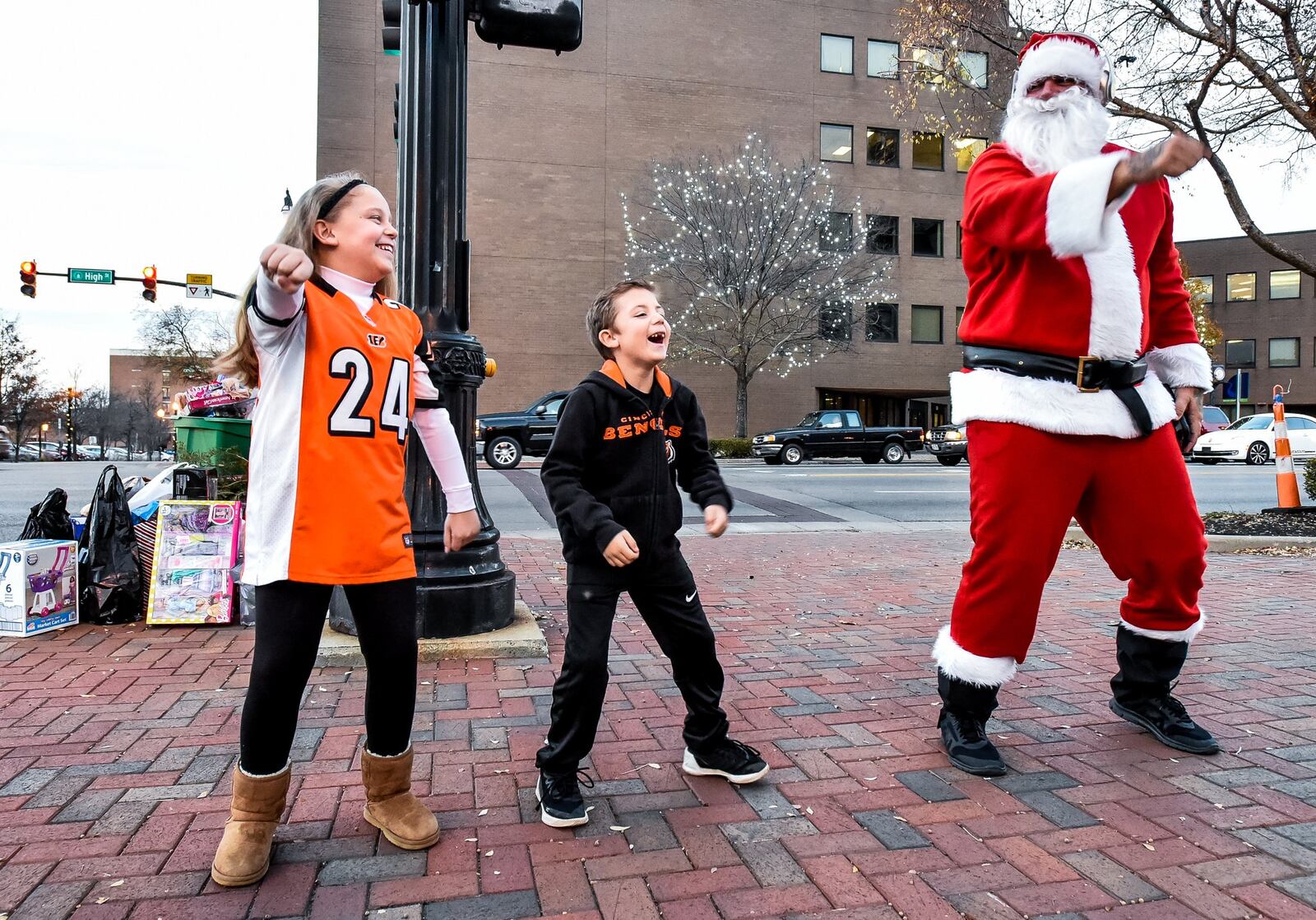 John Drury, dressed up as Santa, dances with local children as he collects toys Wednesday for those in need in front of the historic Butler County Courthouse on High Street in Hamilton. NICK GRAHAM/STAFF