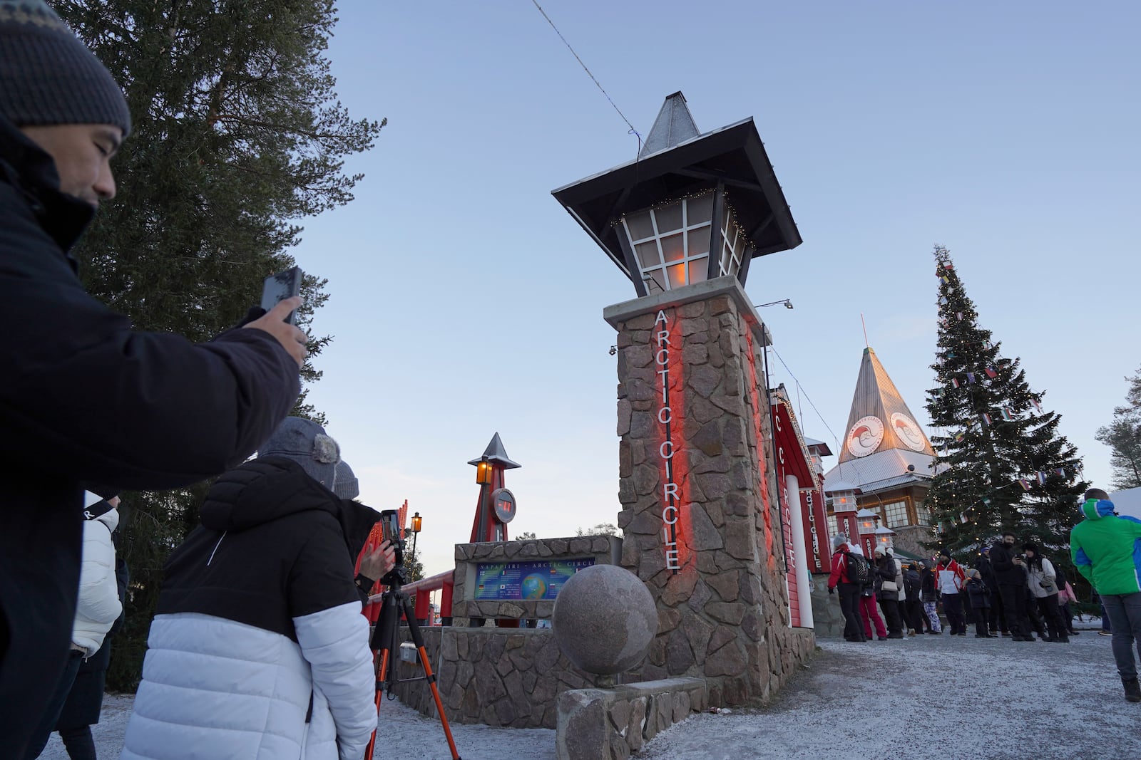 Tourists visit Santa Claus Village, a winter-themed amusement park perched on the edge of the Arctic Circle, in Rovaniemi, Finland, Wednesday, Dec. 4, 2024. (AP Photo/James Brooks)