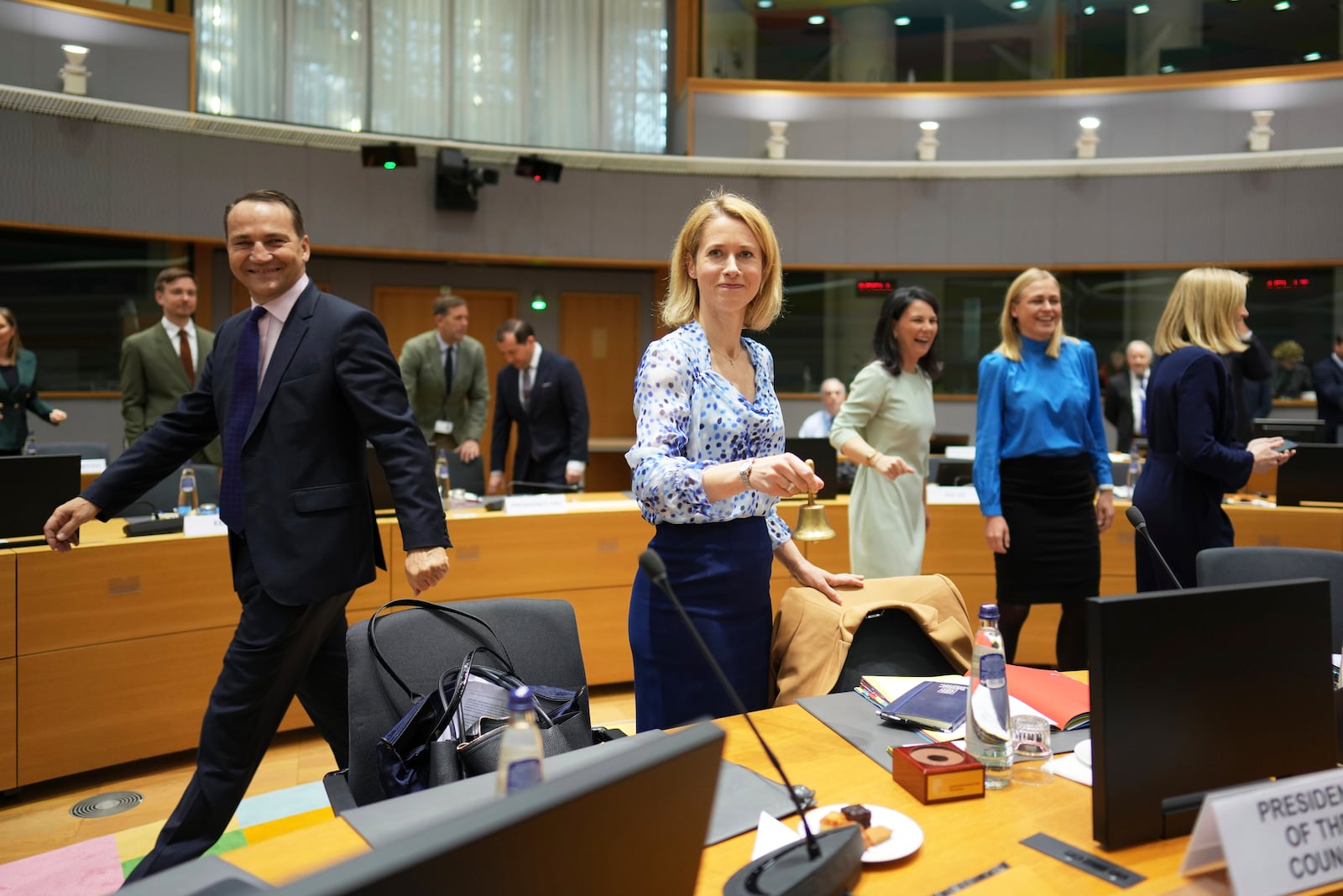 Poland's Foreign Minister Radoslaw Sikorski, left, walks by as European Union foreign policy chief Kaja Kallas, center, rings a bell to signify the start of a round table meeting of EU foreign ministers at the European Council building in Brussels, Monday, March 17, 2025. (AP Photo/Virginia Mayo)