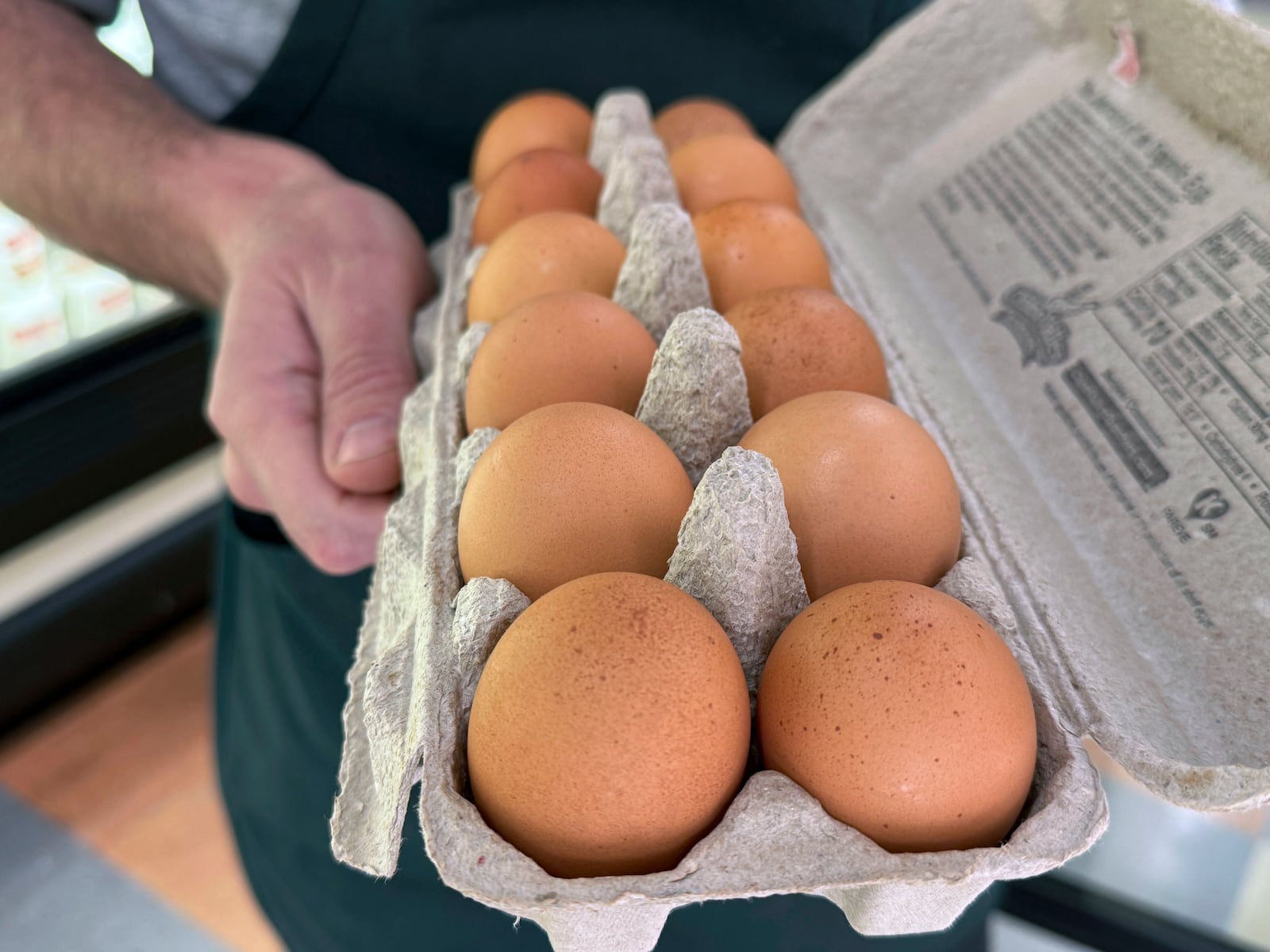 Joe Trimble, owner of Encinal Market, holds an open carton of eggs in Alameda, Calif., on Tuesday, Feb. 11, 2025. (AP Photo/Terry Chea)