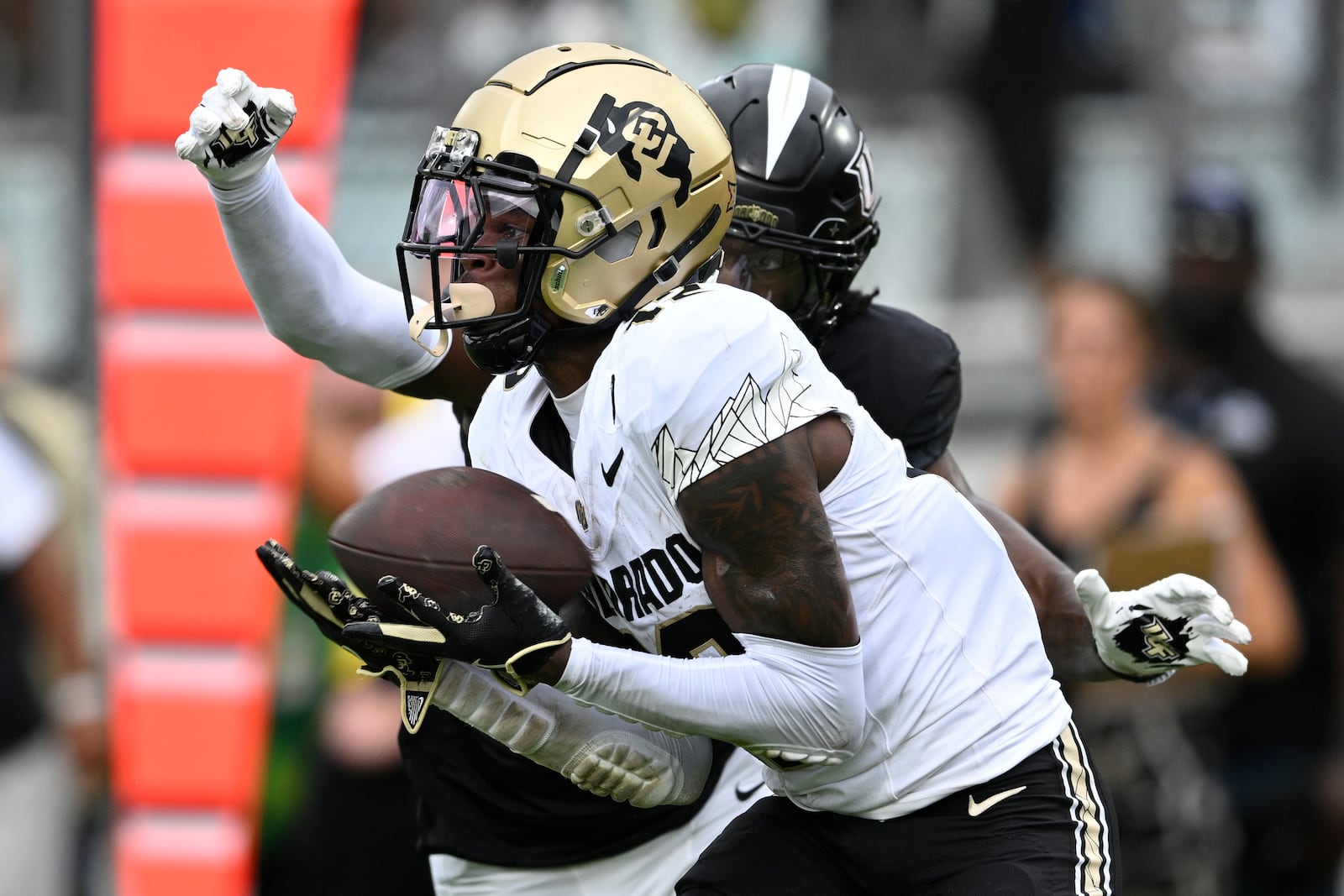 FILE - Colorado wide receiver Travis Hunter (12) catches a pass in the end zone for a 23-yard touchdown reception ahead of Central Florida defensive back Brandon Adams during the first half of an NCAA college football game, Saturday, Sept. 28, 2024, in Orlando, Fla. (AP Photo/Phelan M. Ebenhack, File)