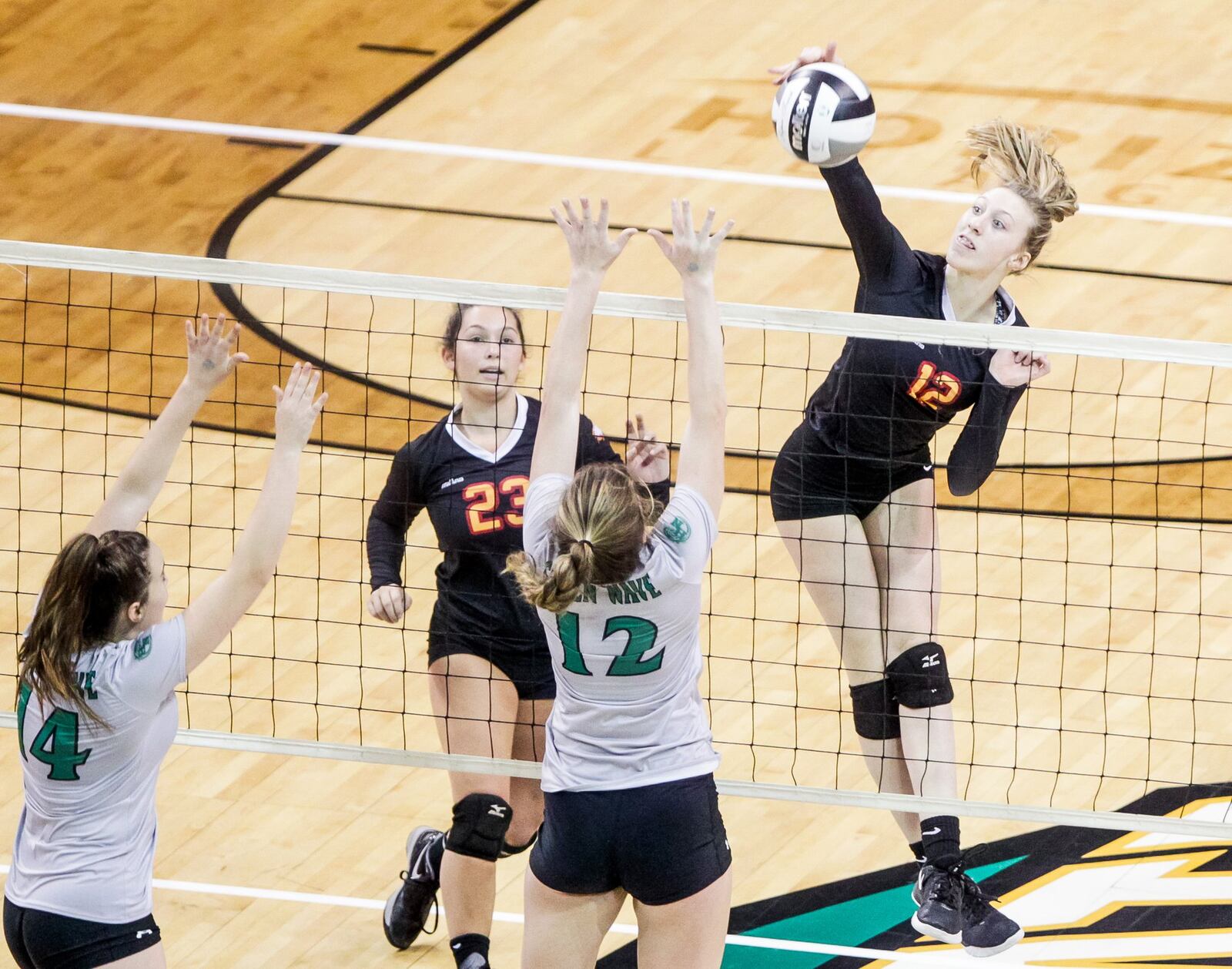 Fenwick’s Kate Hafer drills the ball toward Parma Heights Holy Name’s Kayla Jarosz during Friday’s Division II state volleyball semifinal at Wright State University’s Nutter Center. NICK GRAHAM/STAFF