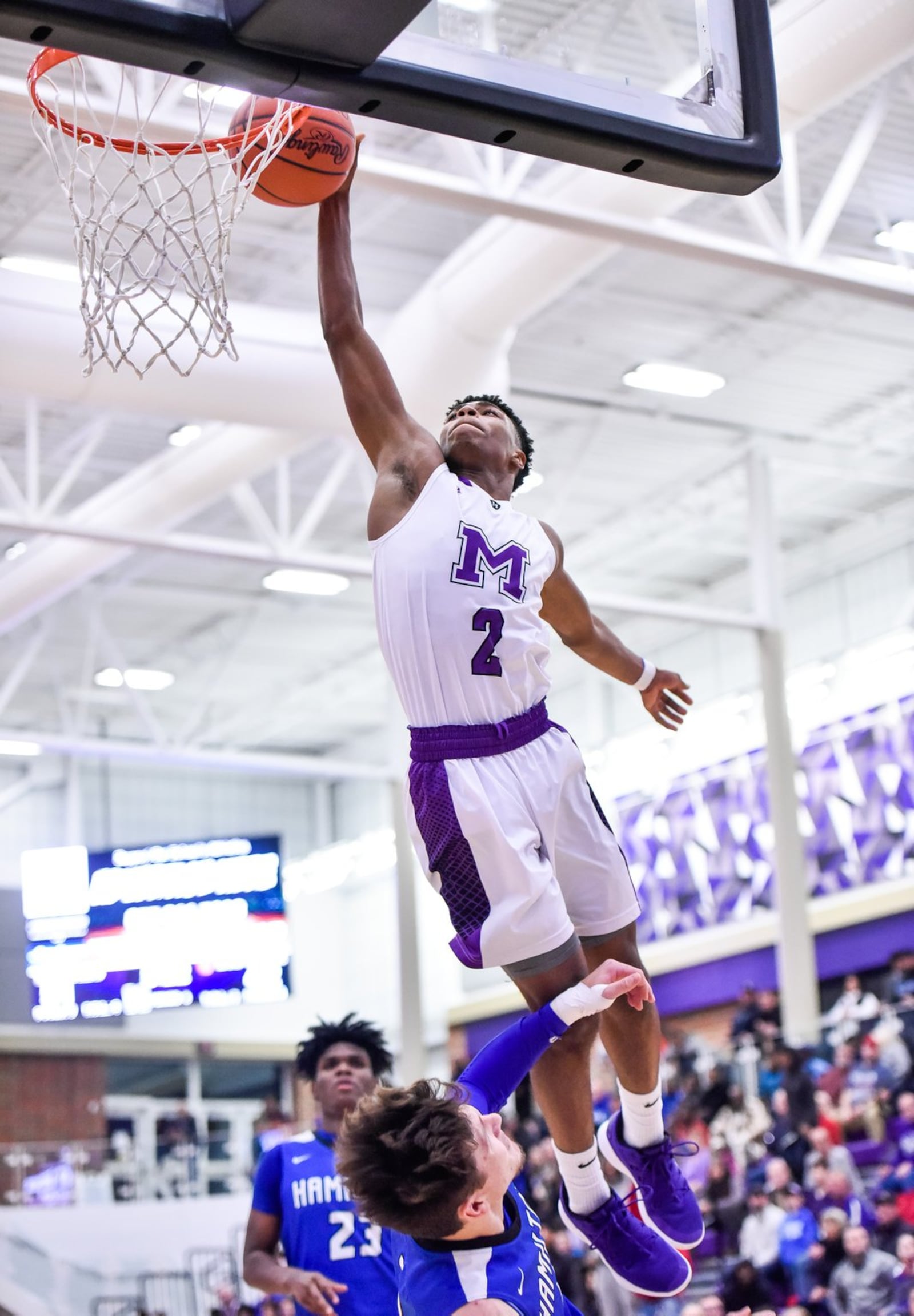 Middletown’s Shandon Morris soars for a basket over Hamilton’s Kurtis Reid during Friday night’s game at Wade E. Miller Arena in Middletown. NICK GRAHAM/STAFF