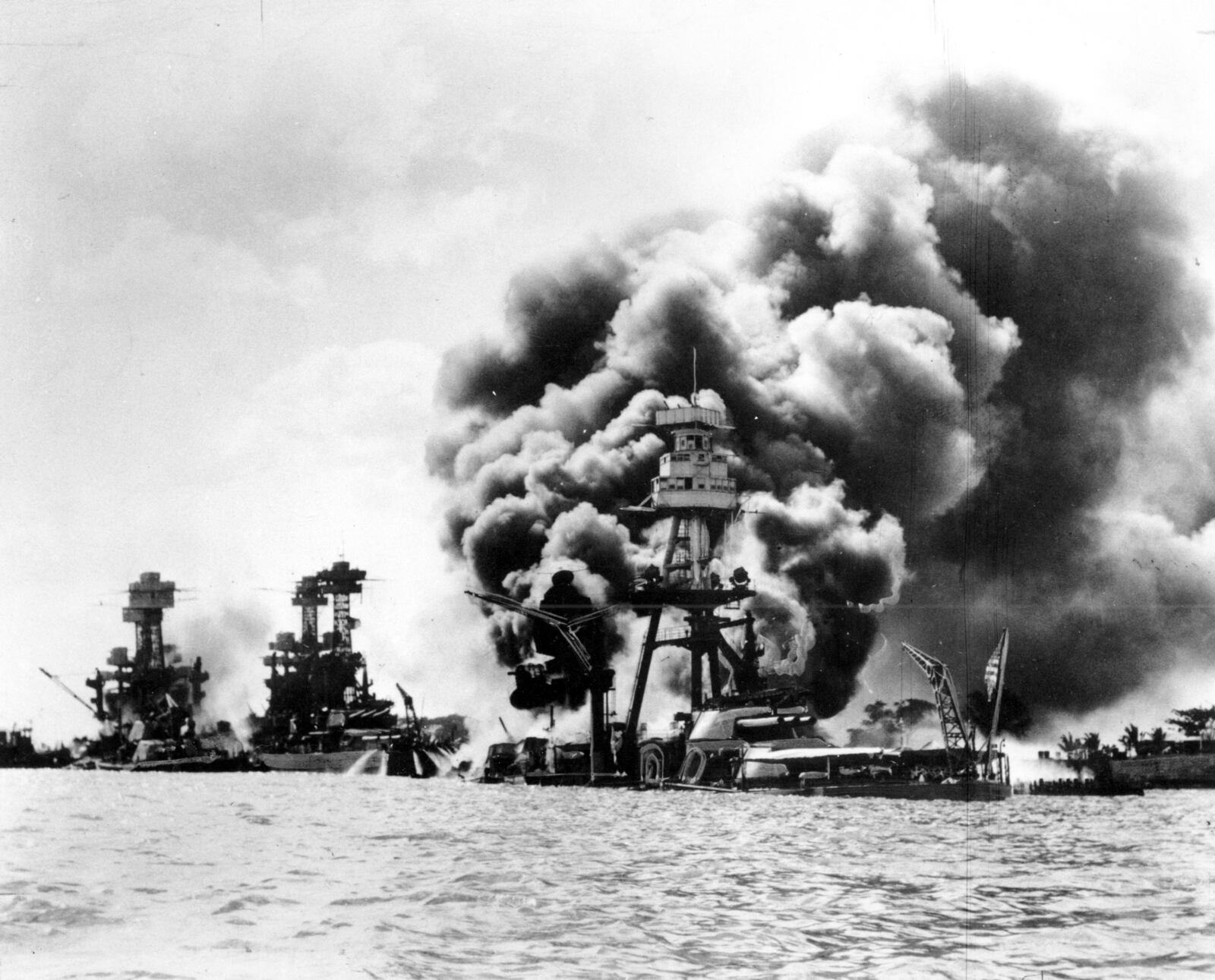 FILE - Three U.S. battleships are hit from the air during the Japanese attack on Pearl Harbor on Dec. 7, 1941. World War II veteran Joseph Eskenazi, who at 104 years and 11 months old is the oldest living veteran to survive the attack on Pearl Harbor, is celebrating his upcoming 105th birthday at the National World War II Museum in New Orleans on Wednesday, Jan. 11, 2023. (U.S. Navy via AP Photo, File)