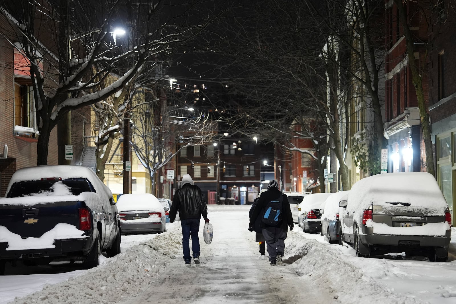 Unhoused people walk down a street toward a shelter after waking up, Tuesday, Jan. 7, 2025, in Cincinnati. (AP Photo/Joshua A. Bickel)