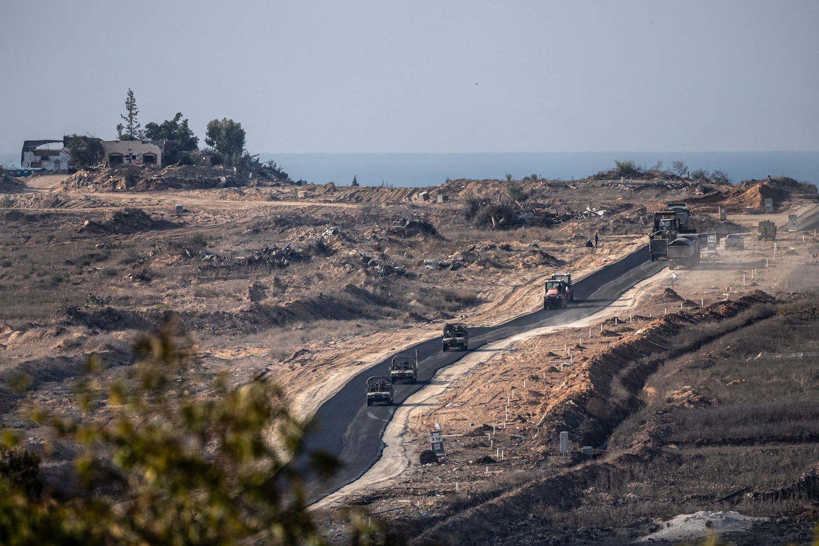 Israeli armoured vehicles move on in an area at the Israeli-Gaza border, seen from southern Israel, Tuesday, Dec. 3, 2024. (AP Photo/Tsafrir Abayov)