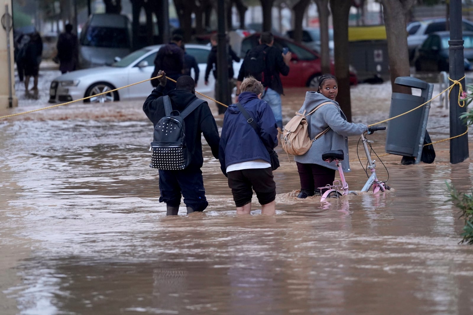 People walk through flooded streets in Valencia, Wednesday, Oct. 30, 2024. (AP Photo/Alberto Saiz)