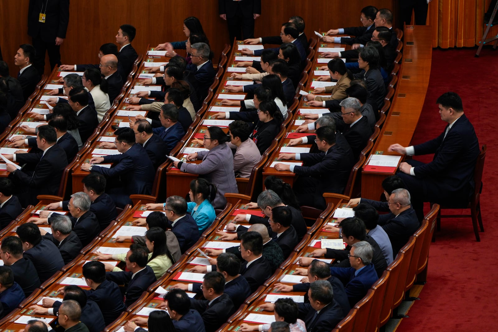 Former Chinese basketball player Yao Ming, right and other delegates press buttons to vote during the closing ceremony of the National People's Congress held at the Great Hall of the People in Beijing, Tuesday, March 11, 2025. (AP Photo/Ng Han Guan)