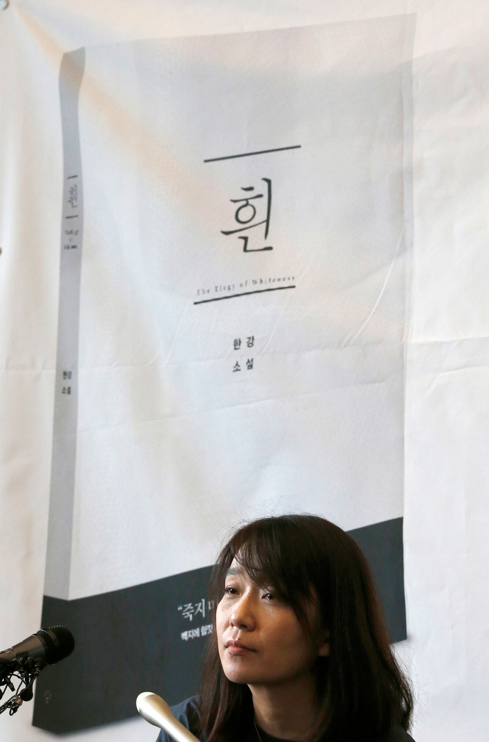 FILE - South Korean author Han Kang listens to a reporter's question in front of a banner of her new fiction during a news conference in Seoul, South Korea, Tuesday, May 24, 2016. Kang has won the Nobel Prize for Literature. (AP Photo/Lee Jin-man, File)