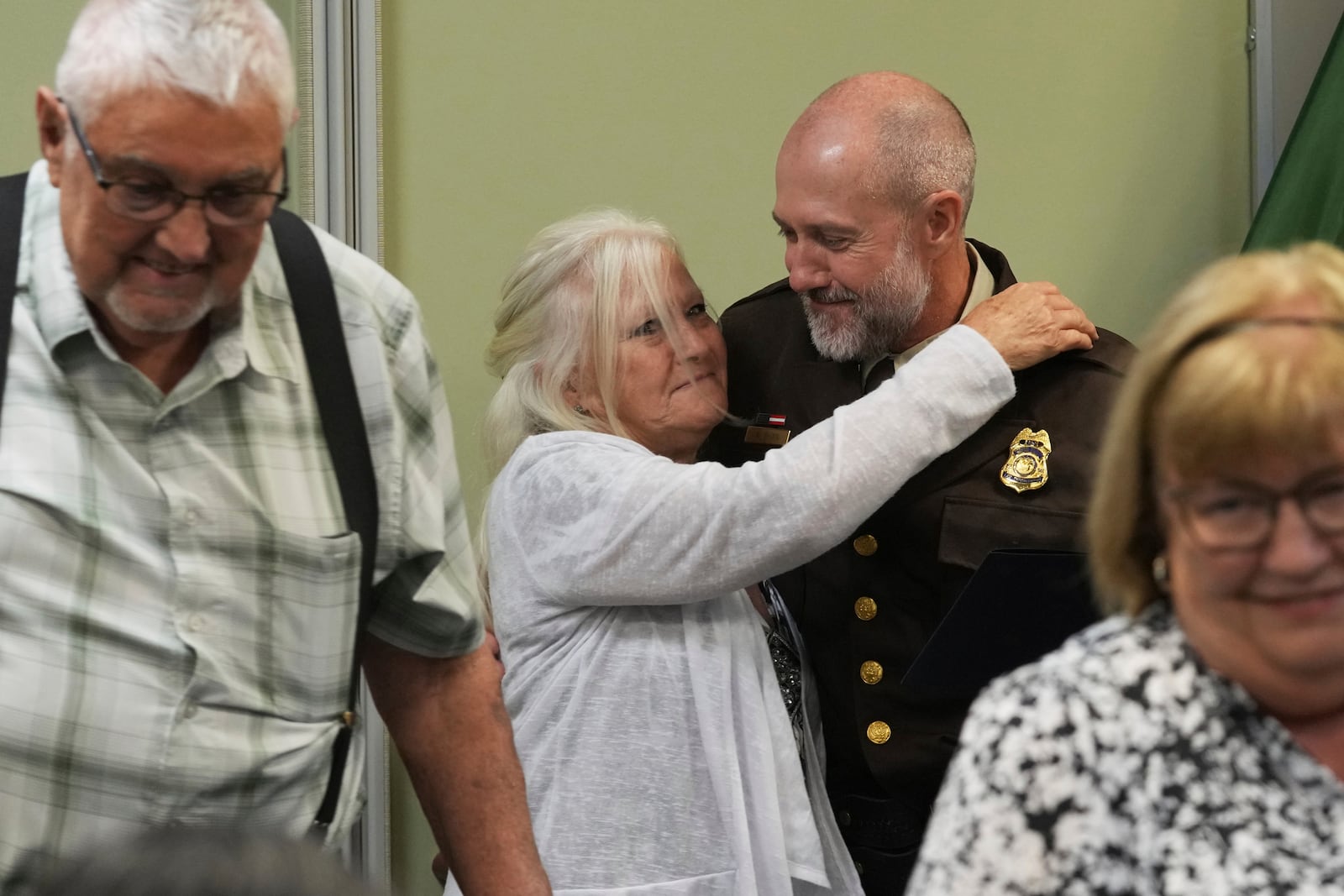 U.S. Fish and Wildlife law enforcement agent is surrounded by his family following the Border Patrol Chaplain Academy graduation, Thursday, Nov. 21, 2024, in Dania Beach, Fla. (AP Photo/Marta Lavandier)