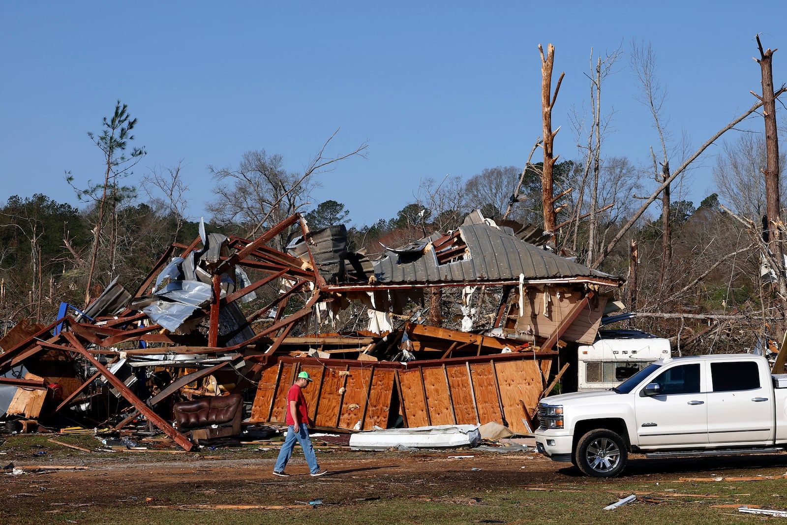 Residents look for personal belongings in the damage after a tornado passed through where two people lost their lives, Sunday, March 16, 2025, in Plantersville, Ala. (AP Photo/Butch Dill)