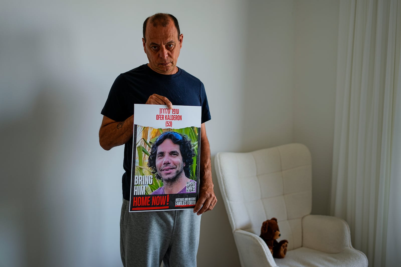 FILE - Nissan Kalderon poses in Ramat Gan, Israel, on Wednesday, March 13, 2024, with a photo of his only brother, Ofer Kalderon, a hostage held in the Gaza Strip by the Hamas militant group. (AP Photo/Ariel Schalit, File)