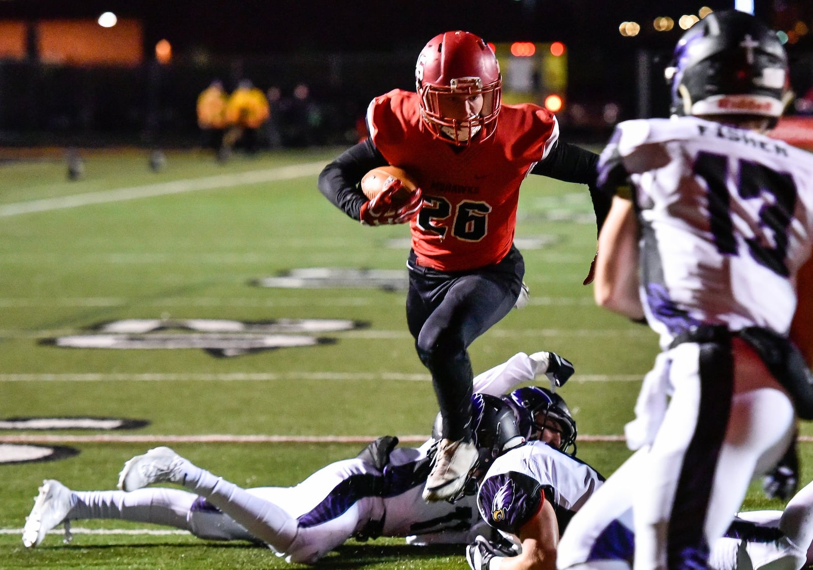 The Cincinnati Hills Christian Academy defense, including Cole Fisher (13), can’t stop Madison’s Cameron Svarda (26) from scoring a first-half touchdown Friday night during a Division V, Region 20 semifinal at Lakota East. NICK GRAHAM/STAFF