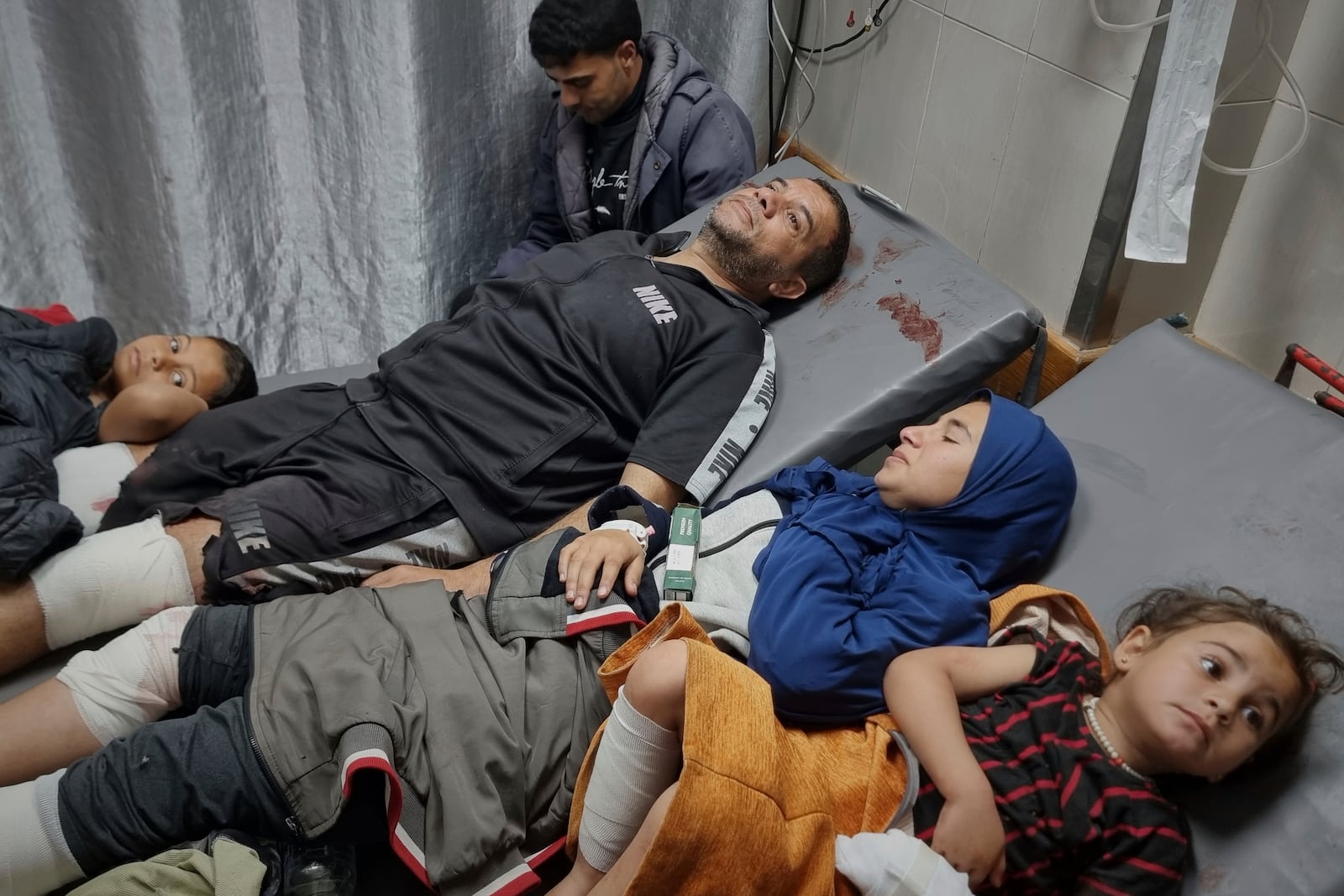 Injured Palestinians wait for treatment at the hospital following Israeli army airstrikes in Khan Younis, southern Gaza Strip, Tuesday, March 18, 2025. (AP Photo/Mohammad Jahjouh)