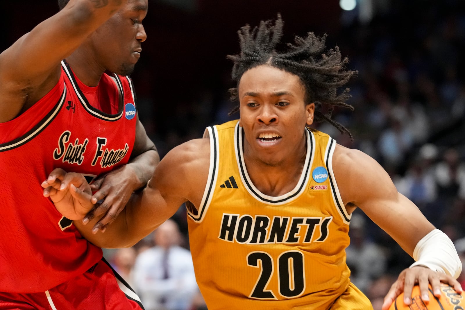 Alabama State's TJ Madlock (20) drives against Saint Francis' Daemar Kelly during the second half of a First Four college basketball game in the NCAA Tournament, Tuesday, March 18, 2025, in Dayton, Ohio. (AP Photo/Jeff Dean)