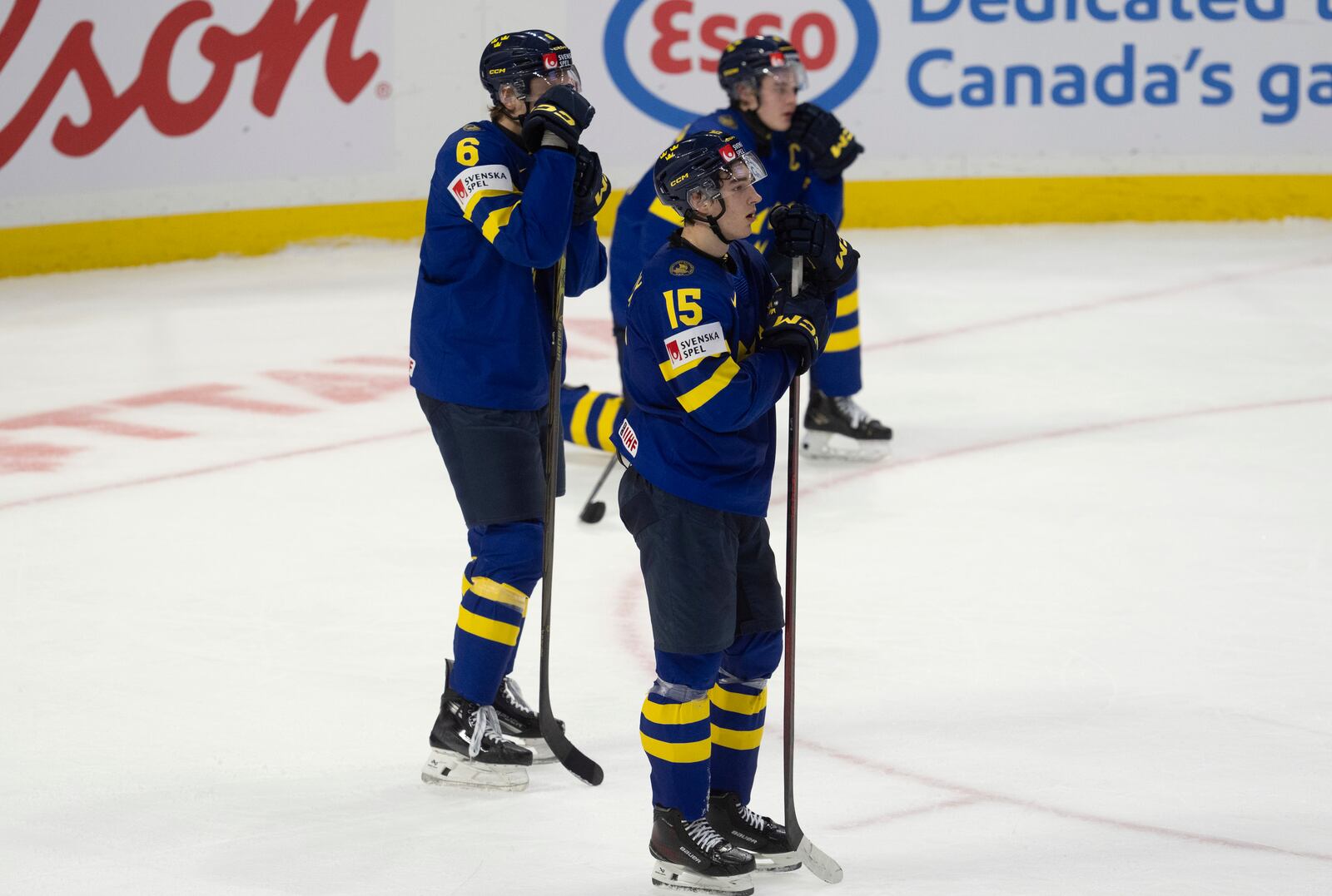 Sweden forward David Edstrom (15) and teammates Axel Hurtig (6) and Axel Sandin Pellikka react after losing in overtime against Finland in semifinal game at the world junior hockey championship, Saturday, Jan. 4, 2025 in Ottawa, Ontario. (Adrian Wyld/The Canadian Press via AP)