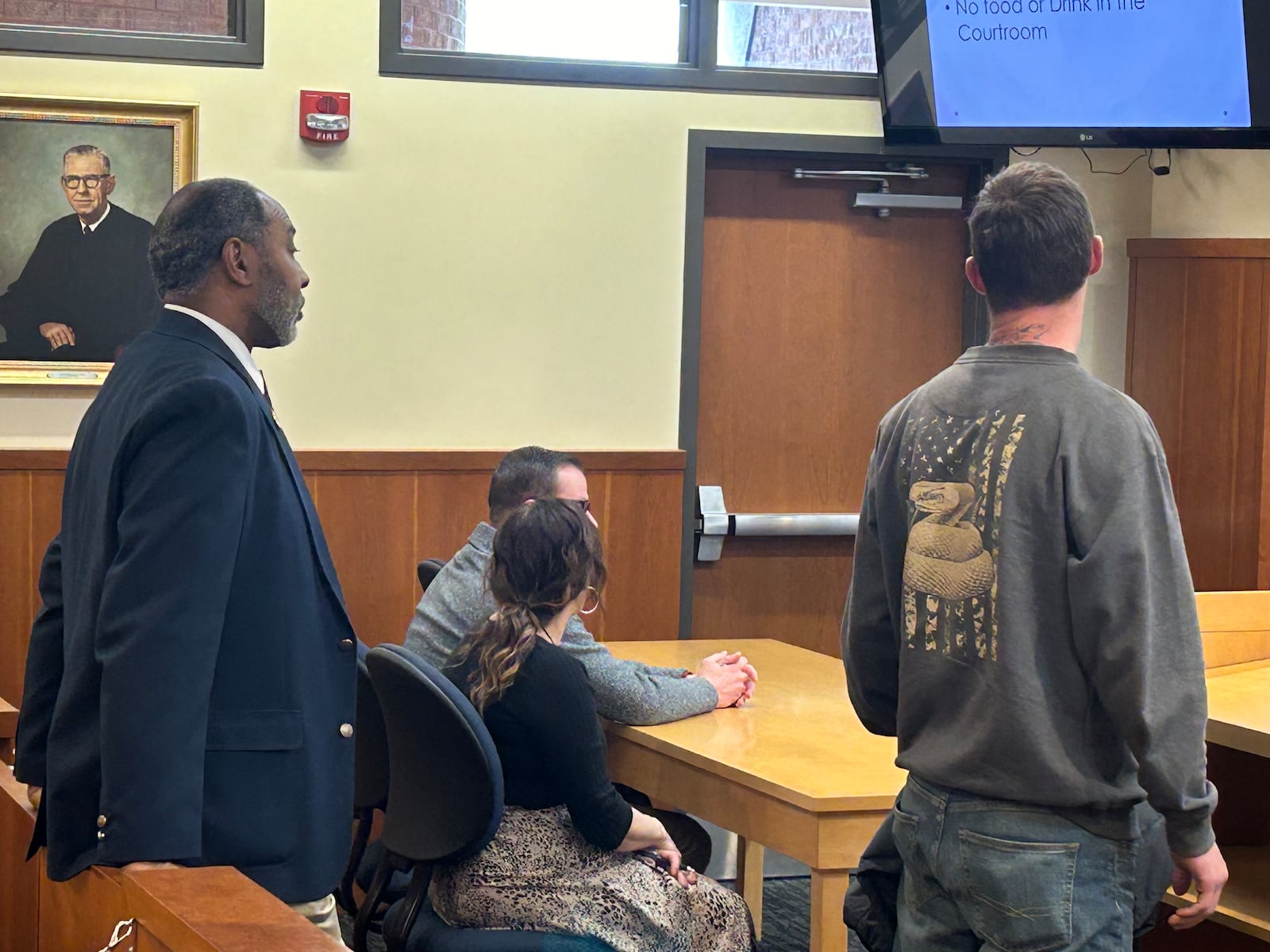 Terry Scott, right, appears before Middletown Municipal Court Judge James Sherron Wednesday afternoon. Scott was charged with littering, a third-degree misdemeanor, and ordered to pay $2,000 in restitution to Berachah Church, where he dumped tile. Pastor Jake Ferguson, sitting at the table with victims' advocate Heather Hellmuth, asks the judge to rescind the fine. Bailiff UD Johnson looks on. RICK McCRABB/STAFF