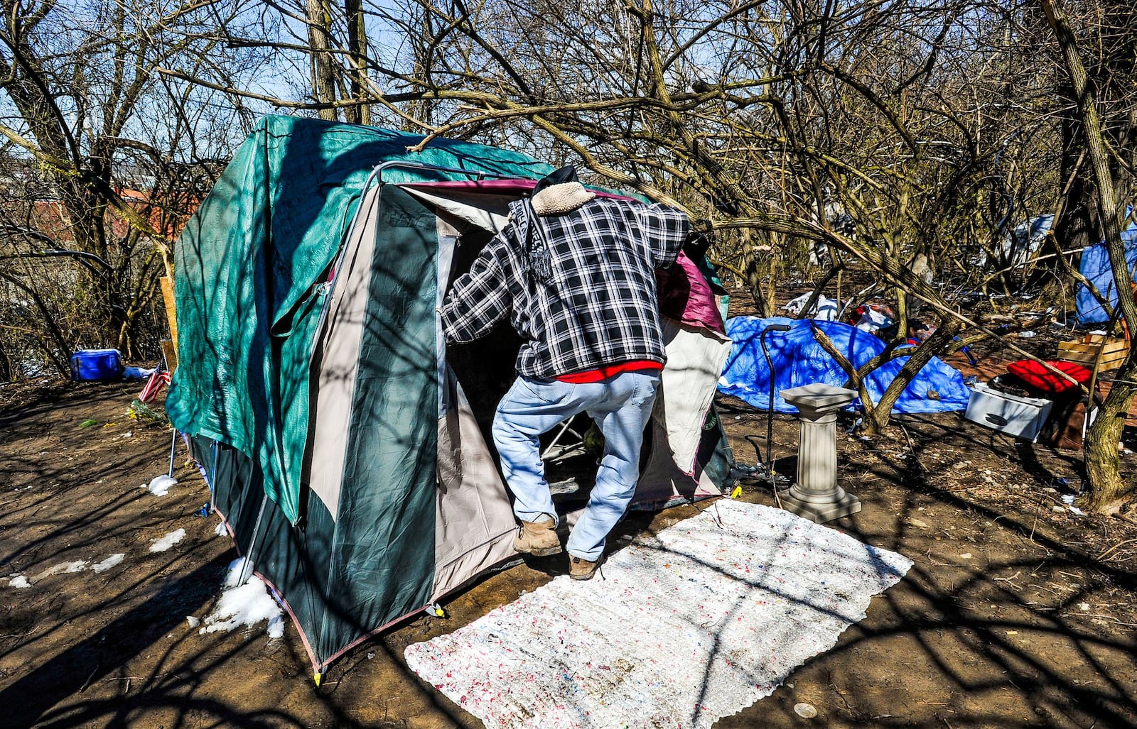 Doug Miller, known as “Pops” around camp, prepares for his day outside the homeless camp behind Hamilton Plaza shopping center Thursday, March 22. Nelson has lived in the camp for nearly a year. NICK GRAHAM/STAFF