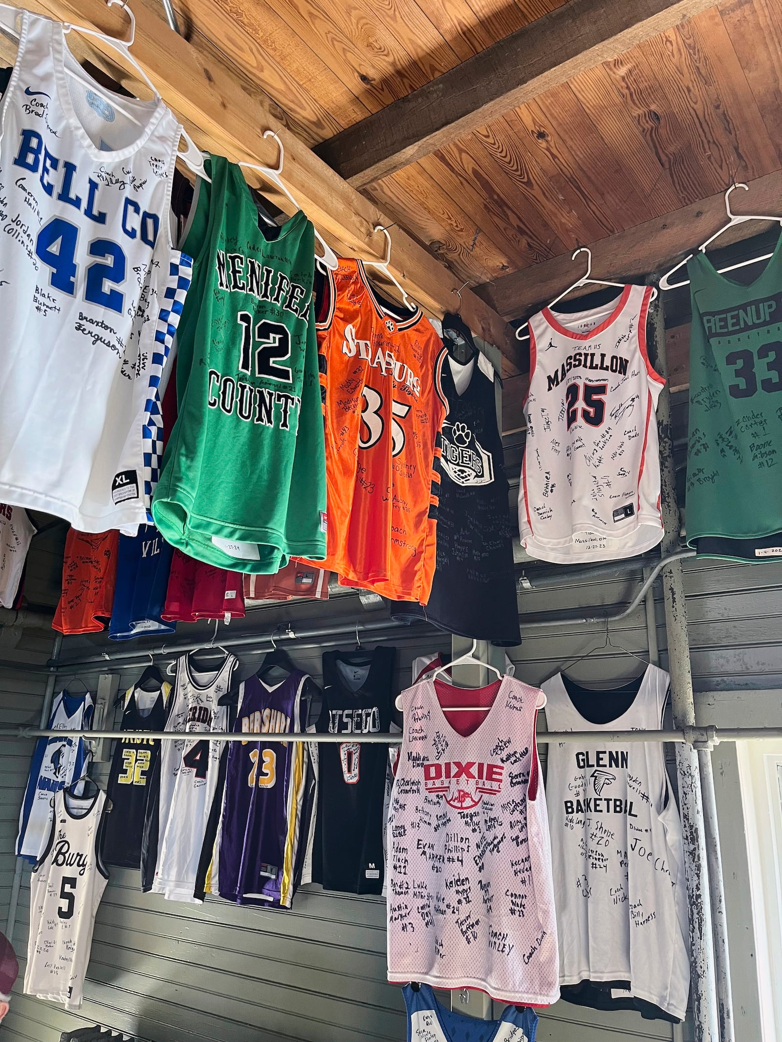 FILE - Signed jerseys left behind by high school teams hang at The Hoosier Gym, where many scenes from the movie "Hoosiers" was filmed in the mid-1980s plays host to dozens of high school games each year as fans still flock to the site, Monday, Feb. 19, 2024, in Knightstown, Ind. (AP Photo/Tim Reynolds, File)