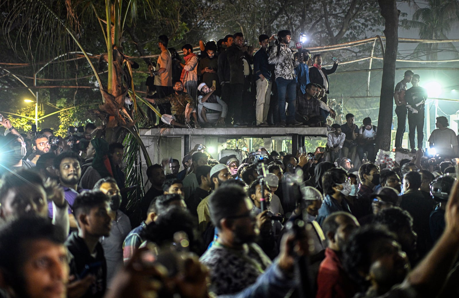 People watch as protesters use heavy machinery to demolish the residence of Sheikh Mujibur Rahman, Bangladesh's former leader and the father of the country's ousted Prime Minister Sheikh Hasina, at Dhanmondi, in Dhaka, Bangladesh, early Thursday, Feb. 6, 2025. (AP Photo/Mahmud Hossain Opu)