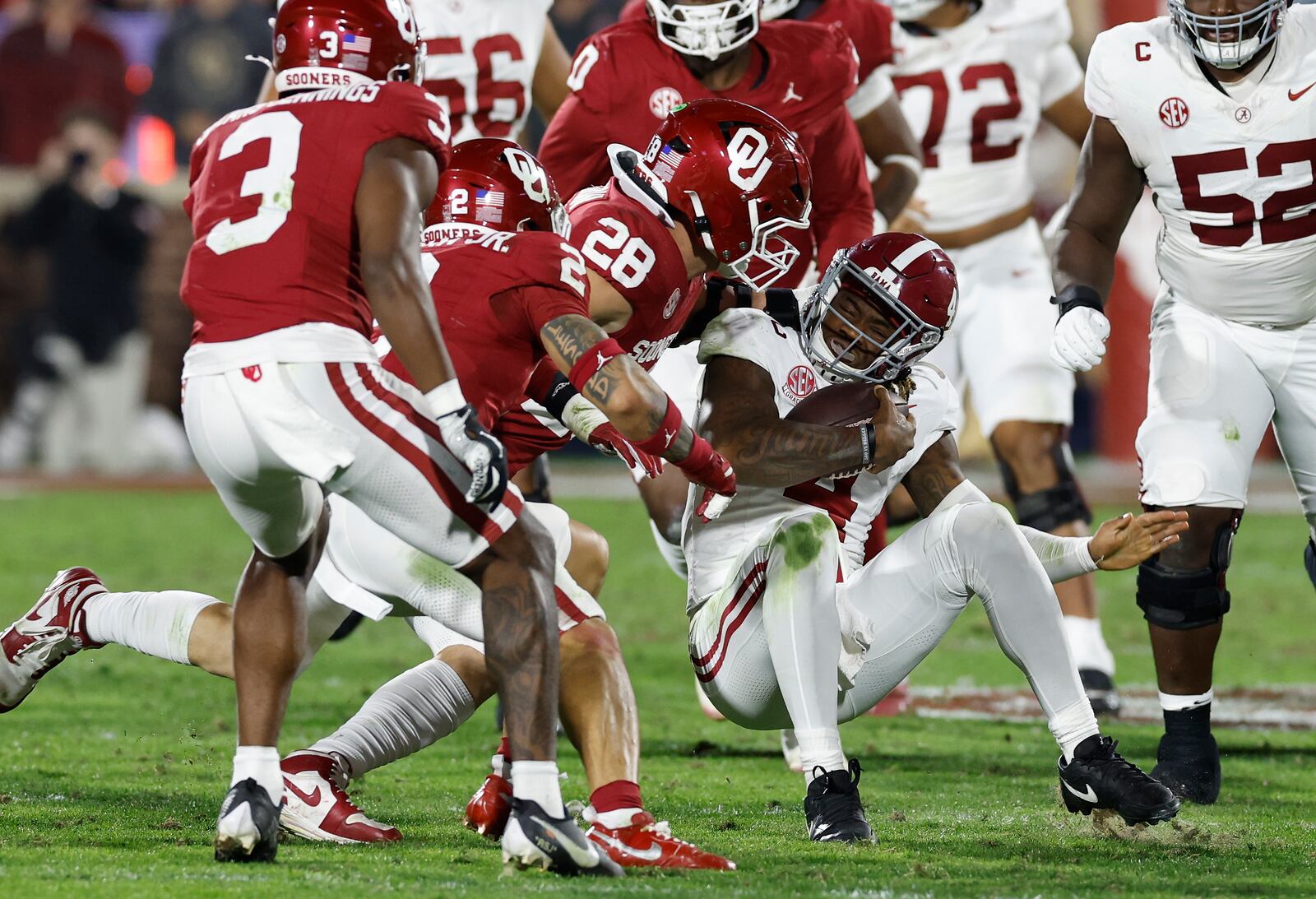 Alabama quarterback Jalen Milroe (4) is tackled by Oklahoma linebacker Danny Stutsman (28) during the second quarter of a NCAA college football game Saturday, Nov. 23, 2024, in Norman, Okla. (AP Photo/Alonzo Adams)