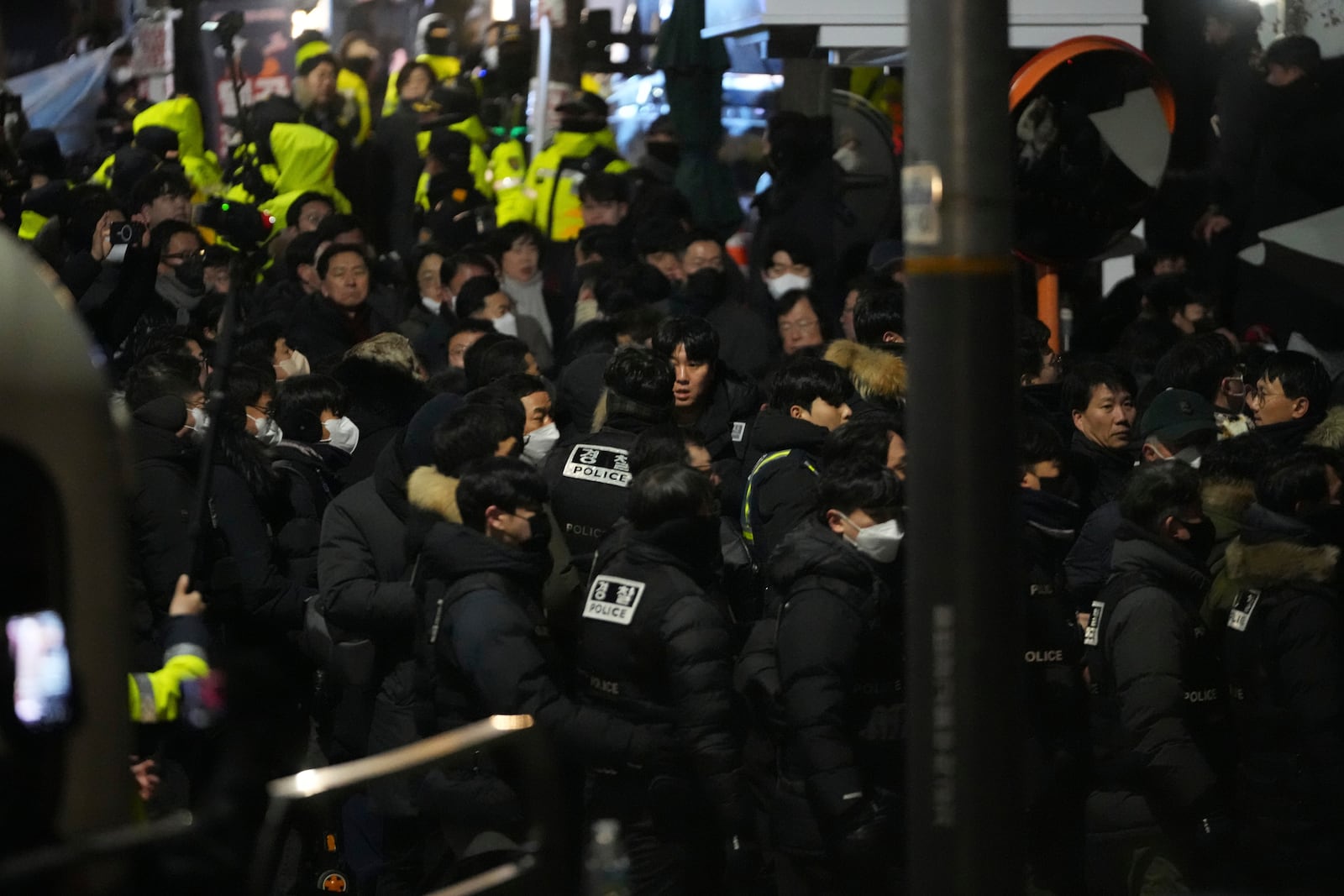 Police officers try to enter as the members of the ruling People Power Party try to block them in front of the gate of the presidential residence in Seoul, South Korea, Wednesday, Jan. 15, 2025. (AP Photo/Lee Jin-man)