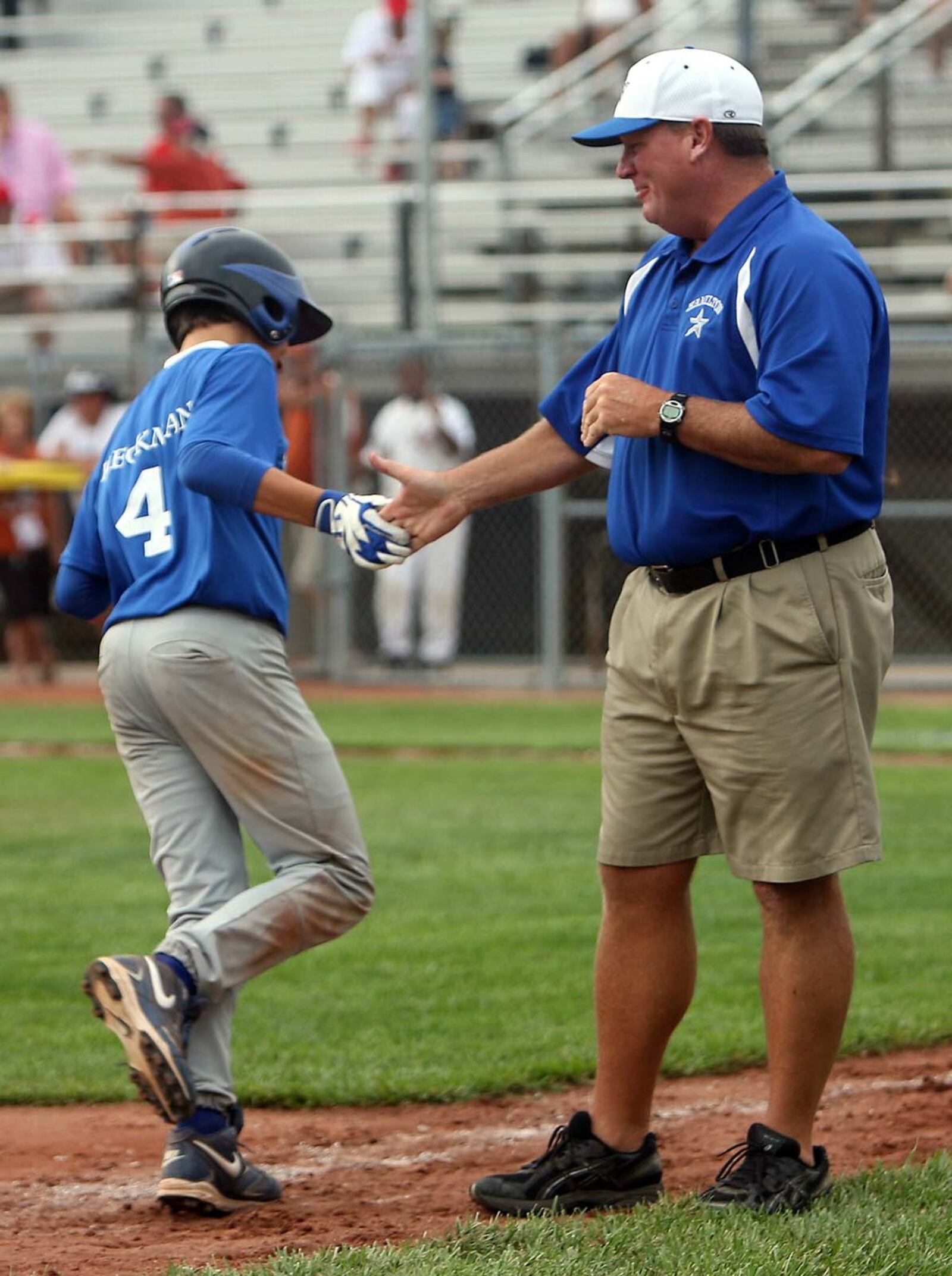 West Side Little League coach Mark Maus congratulates John Heckman after his walk-off home run to end their Great Lakes Regional victory over Russellville (Ky.) on Aug. 7, 2009, in Indianapolis. STAFF PHOTO/GREG LYNCH