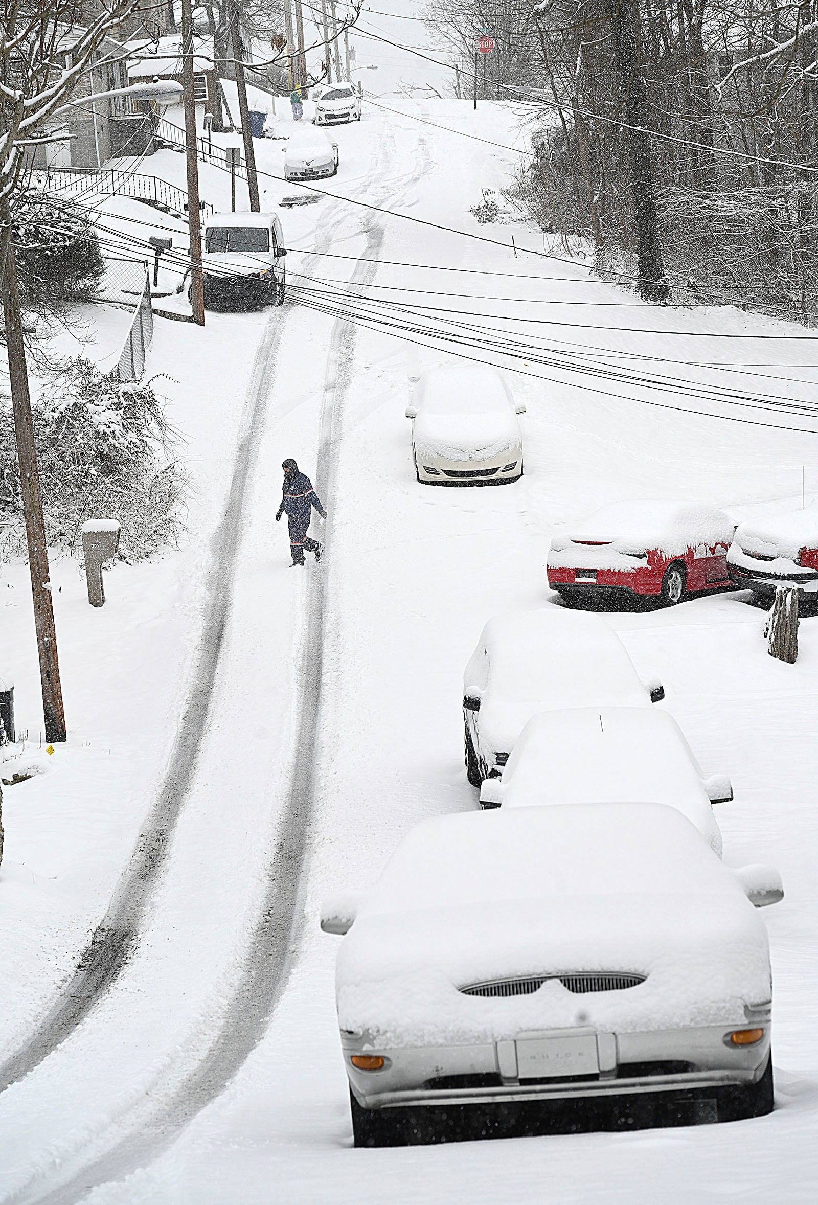 Postal worker delivering mail on Kentucky Ave. in Beckley, W.Va., Tuesday, Feb. 11, 2025. (Rick Barbero/The Register-Herald via AP)