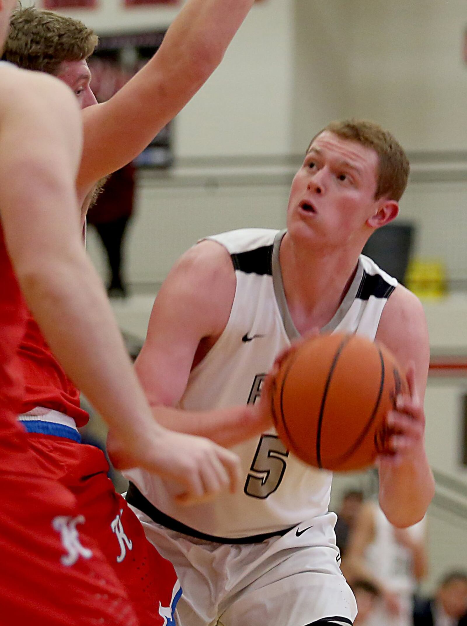 Lakota East forward Evan Kuhlman eyes the hoop before scoring on Kings forward Dan Sichterman during their Division I sectional game at Lakota West on Wednesday night. CONTRIBUTED PHOTO BY E.L. HUBBARD