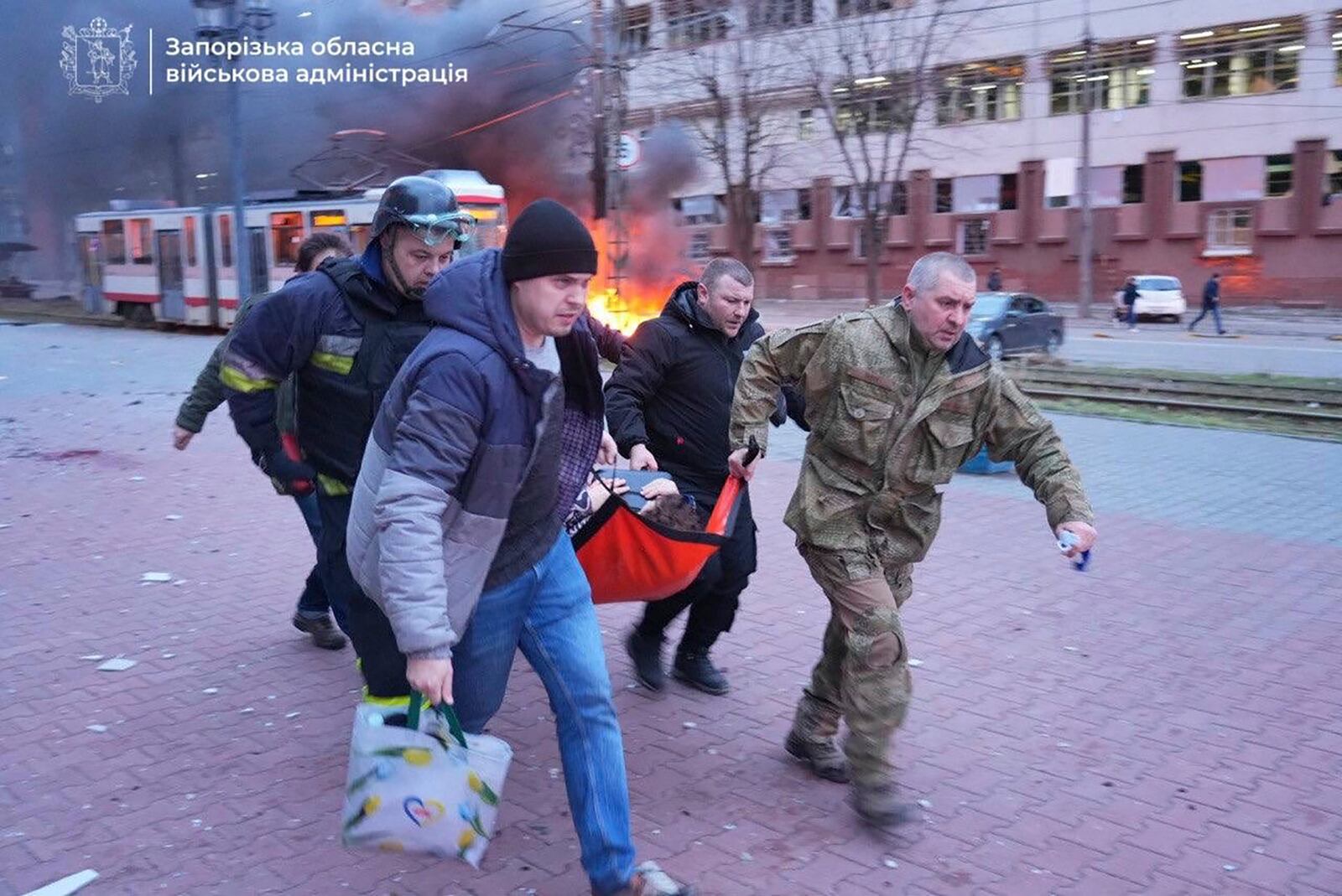 In this photo provided by the Zaporizhzhia regional military administration on Jan. 8, 2025, people carry an injured woman on a stretcher into an ambulance after a Russian air strike in Zaporizhzhia, Ukraine. (Zaporizhzhia regional military administration via AP)