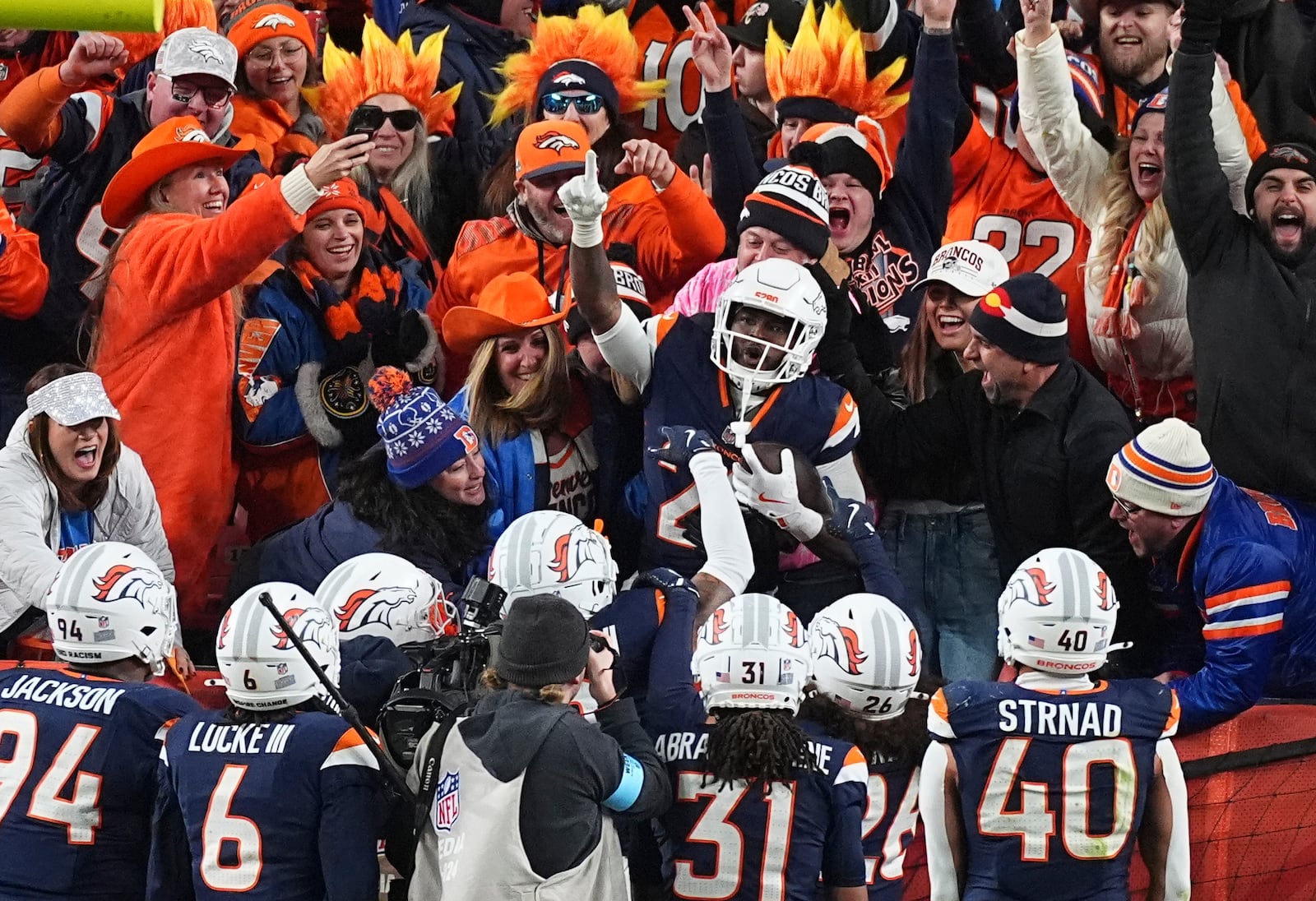 Denver Broncos cornerback Ja'Quan McMillian, center, celebrates with fans after returning an interception for a touchdown in the second half of an NFL football game against the Cleveland Browns, Monday, Dec. 2, 2024, in Denver. (AP Photo/David Zalubowski)