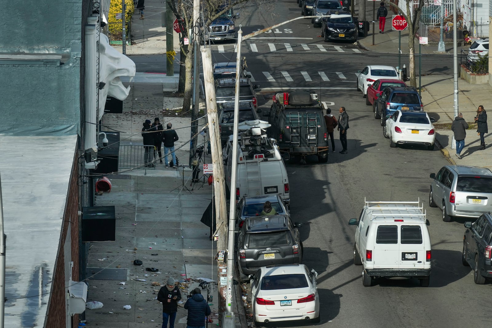 Members of the media work in front of the nightclub Amazura, left, in the Queens borough of New York, Thursday, Jan. 2, 2025. (AP Photo/Seth Wenig)