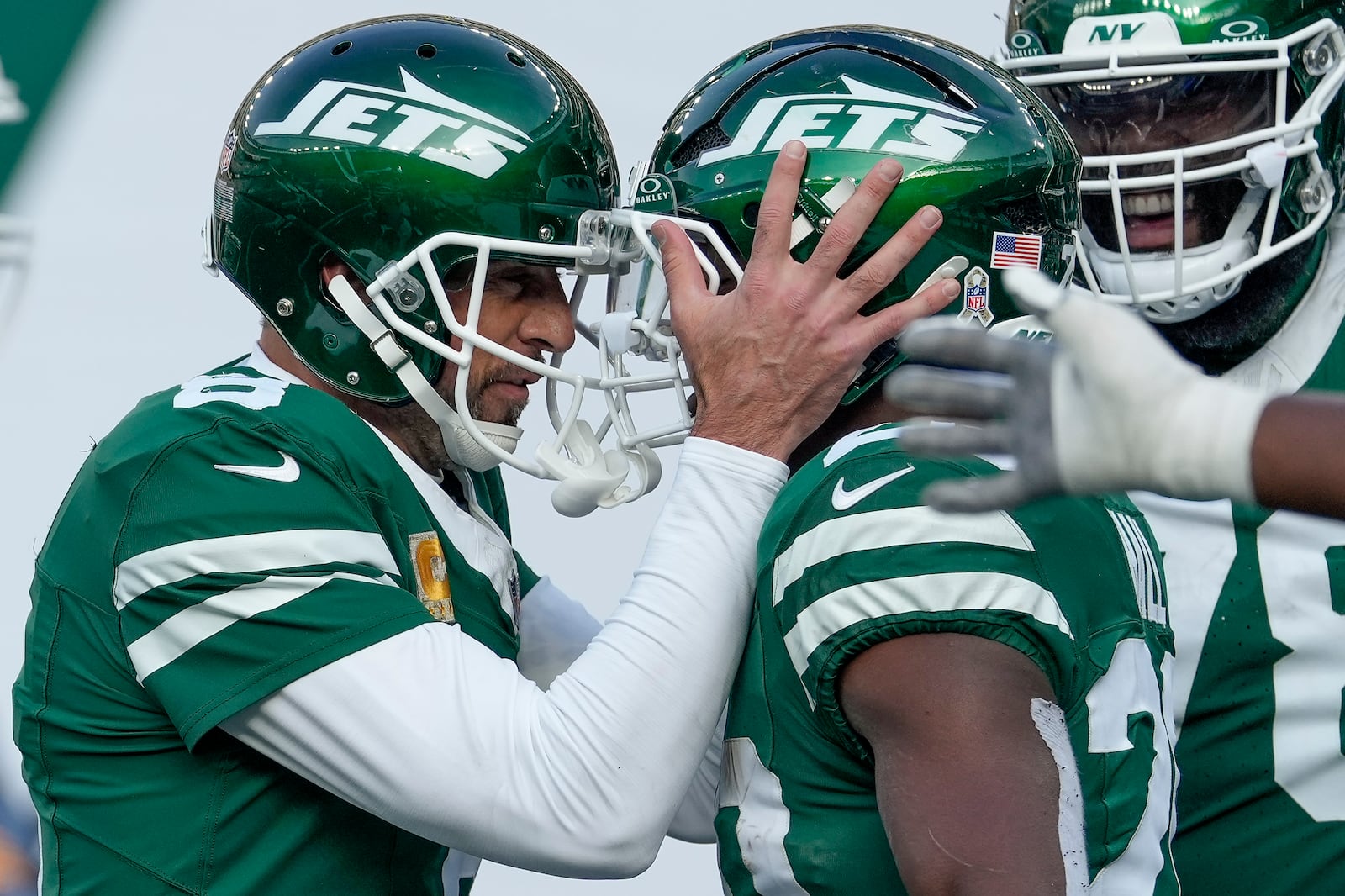 New York Jets quarterback Aaron Rodgers (8) congratulates running back Breece Hall (20) after Hall ran the ball for a touchdown against the Indianapolis Colts during the second quarter of an NFL football game, Sunday, Nov. 17, 2024, in East Rutherford, N.J. (AP Photo/Seth Wenig)