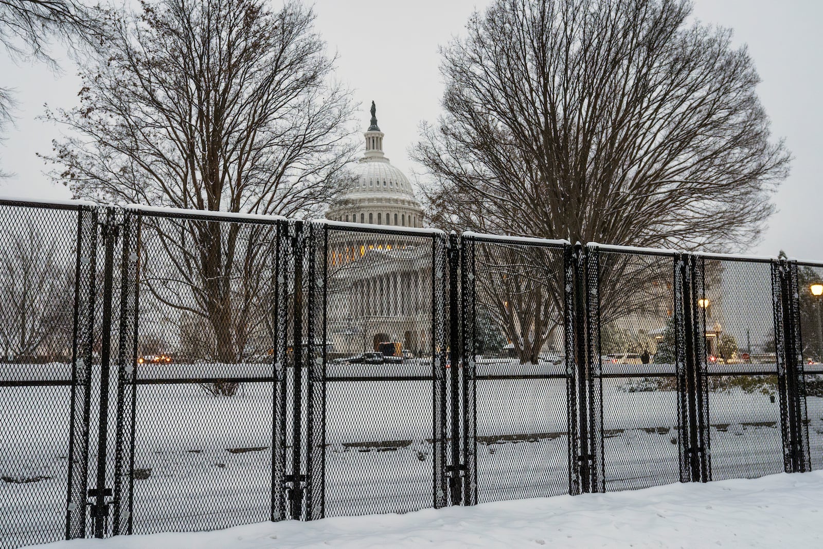 Security fencing surrounds Capitol Hill as snow blankets the region ahead of a joint session of Congress to certify the votes from the Electoral College in the presidential election, in Washington, Monday, Jan. 6, 2025. (AP Photo/J. Scott Applewhite)