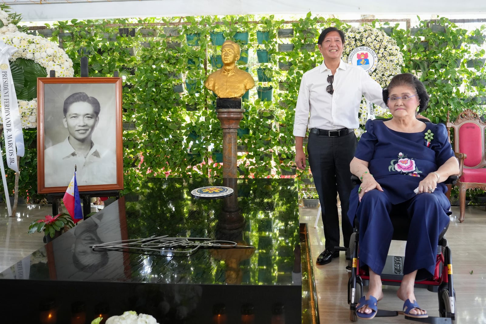 In this handout photo provided by the Malacanang Presidential Communications Office, Philippine President Ferdinand Marcos Jr., left, and his mother former First Lady Imelda Marcos, right, pose as they visit the tomb of the late strongman Ferdinand Marcos at the National Heroes Cemetery in Taguig City, Philippines on All Saints Day on Friday Nov. 1, 2024. (Malacanang Presidential Communications Office via AP)